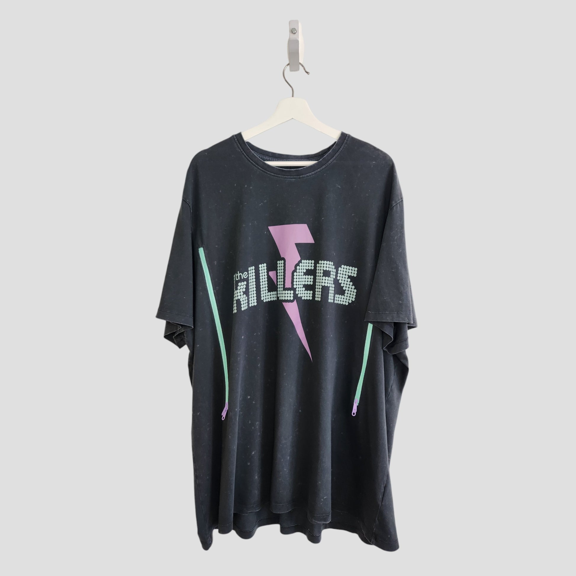 An upcycled 3XL black The Killers band T-shirt for breastfeeding and pumping, featuring white dotted lettering and a pink lightning bolt—a unique find for preloved fashion fans.