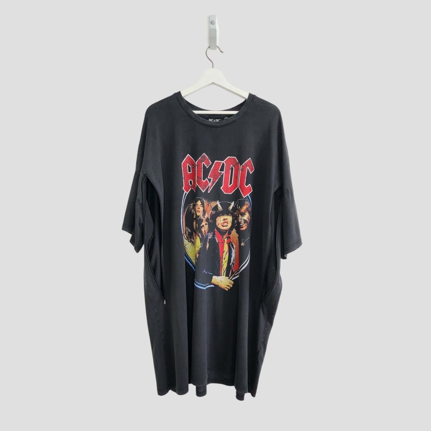An upcycled Primark AC/DC Faces breastfeeding & pumping t-shirt dress (XL/UK18/20) made from preloved materials, hangs on a white hanger against a plain light gray background.