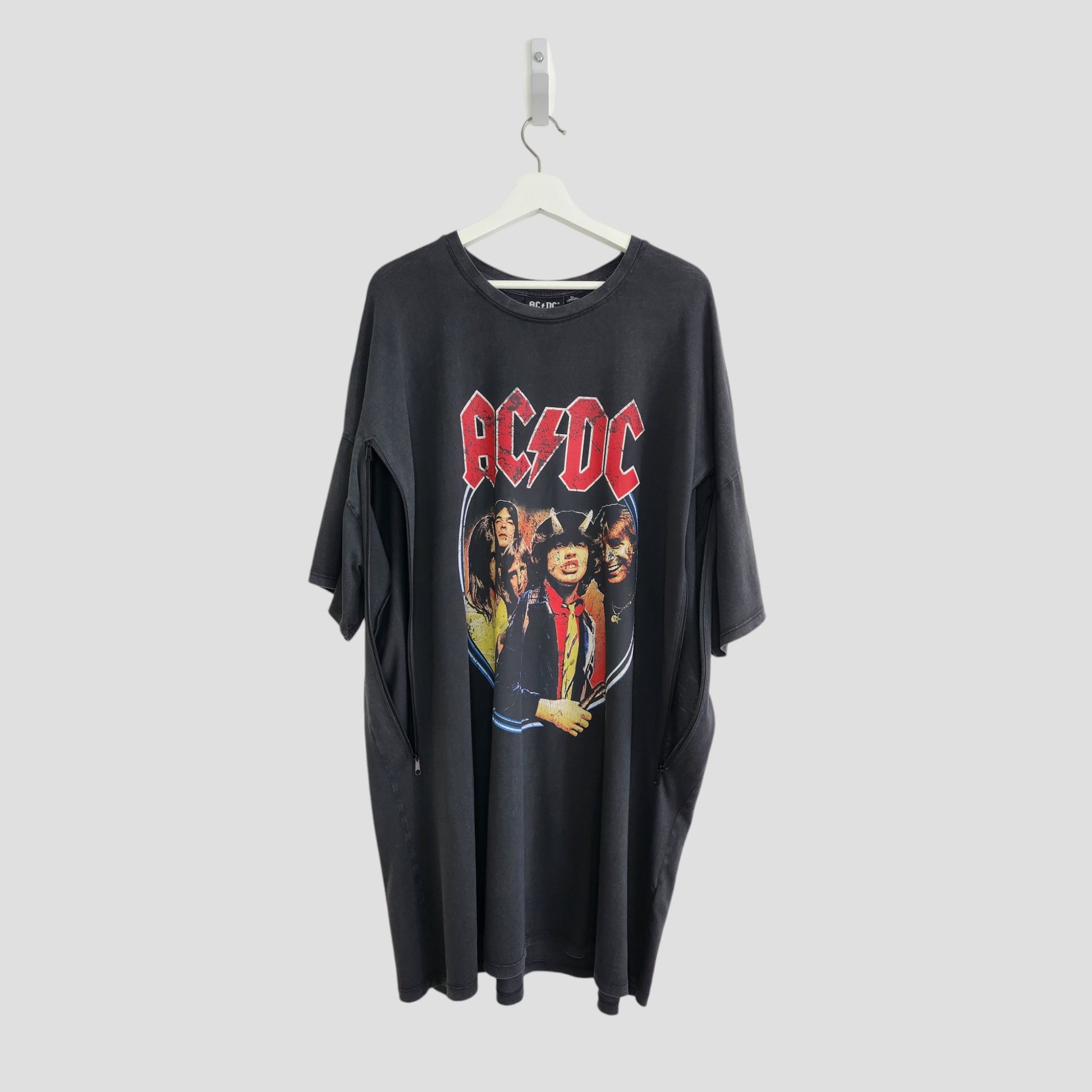 An upcycled Primark AC/DC Faces breastfeeding & pumping t-shirt dress (XL/UK18/20) made from preloved materials, hangs on a white hanger against a plain light gray background.