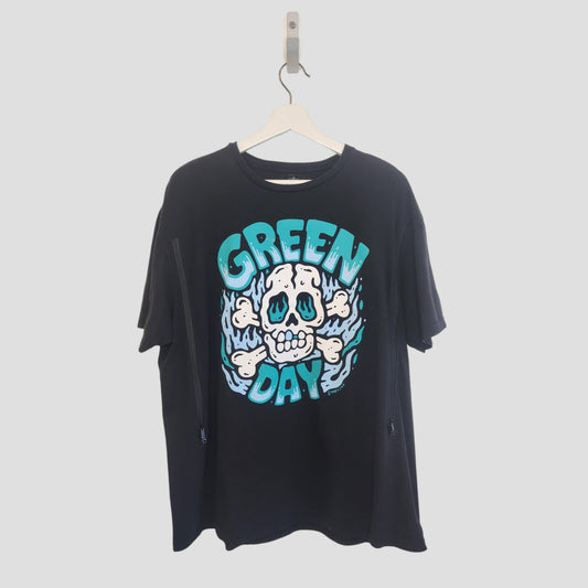 The Gildan Upcycled Breastfeeding & Pumping Black Skull Green Day Band T-shirt (XL, 100187) features a cartoon skull, blue flames, and bold GREEN DAY text in teal and white. It hangs on a white hanger against a plain background.