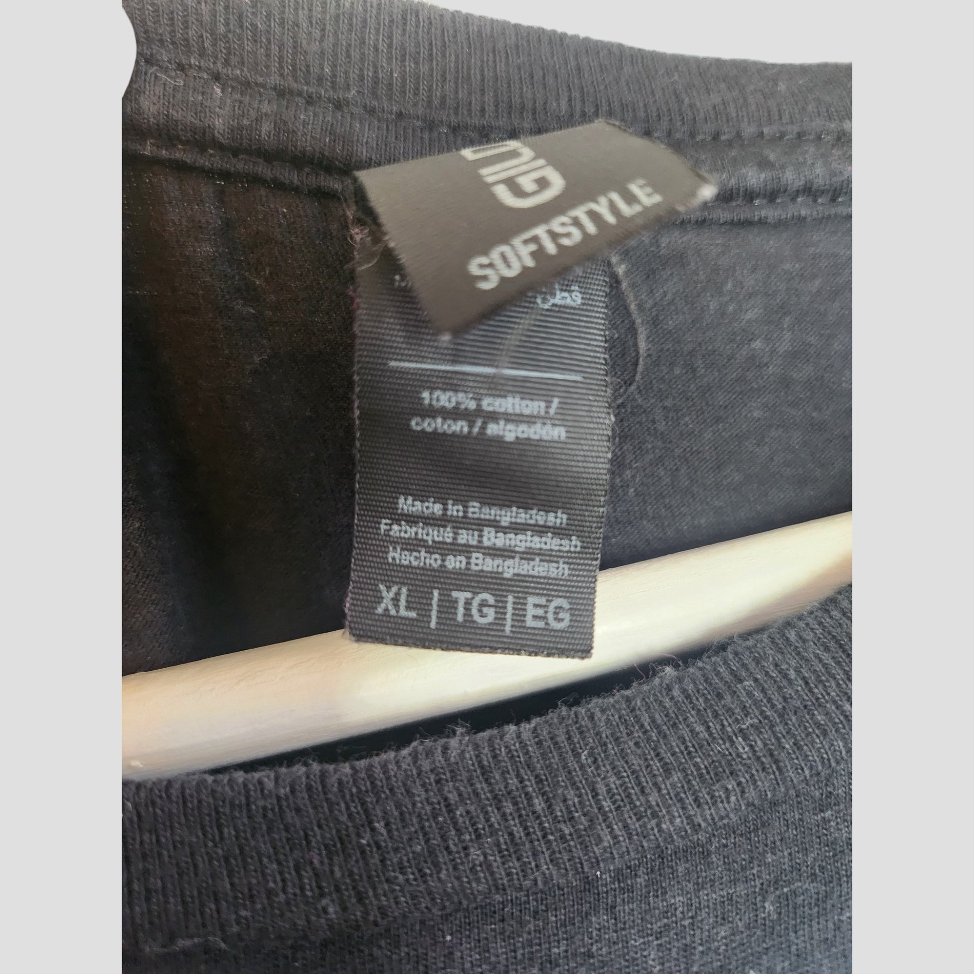 A close-up shows the Gildan label on an upcycled Black Skull Green Day Band breastfeeding & pumping T-shirt, size XL (100187), draped over a wooden hanger—perfect for eco-conscious nursing clothes fans.