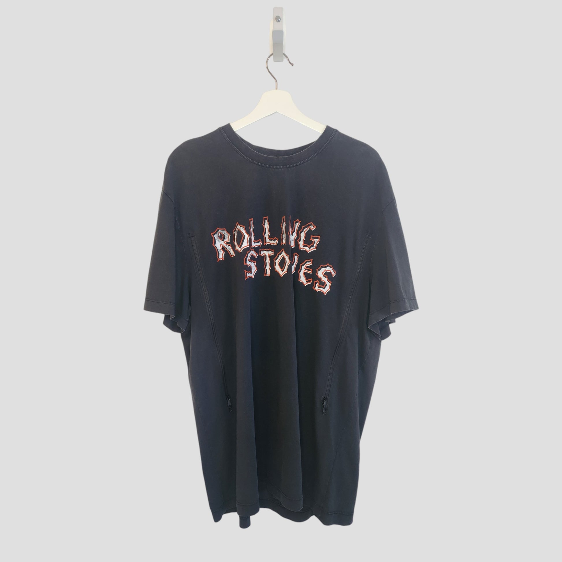 A Primark Upcycled Breastfeeding & Pumping Black Voodoo The Rolling Stones Band T-shirt (XL, 100269) in black, made from repurposed nursing wear, hangs on a white hanger against a plain light background.