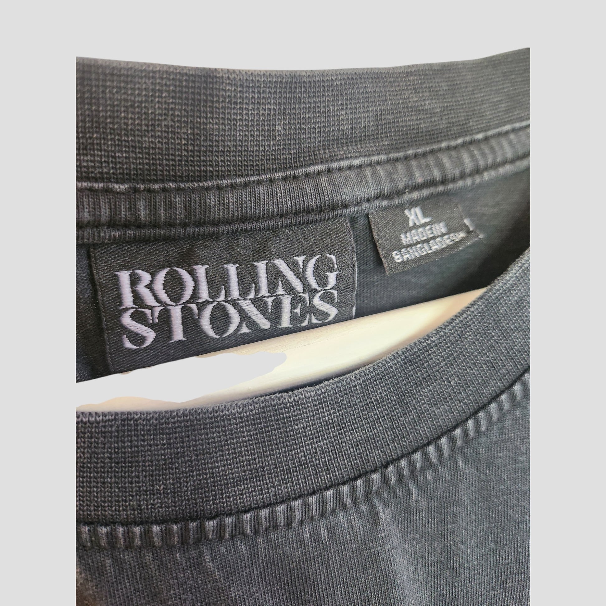 Close-up of a Primark Upcycled Breastfeeding & Pumping Black Voodoo The Rolling Stones Band T-shirt in XL, made in Bangladesh. The label and collar detail highlight the quality stitching and fabric texture.