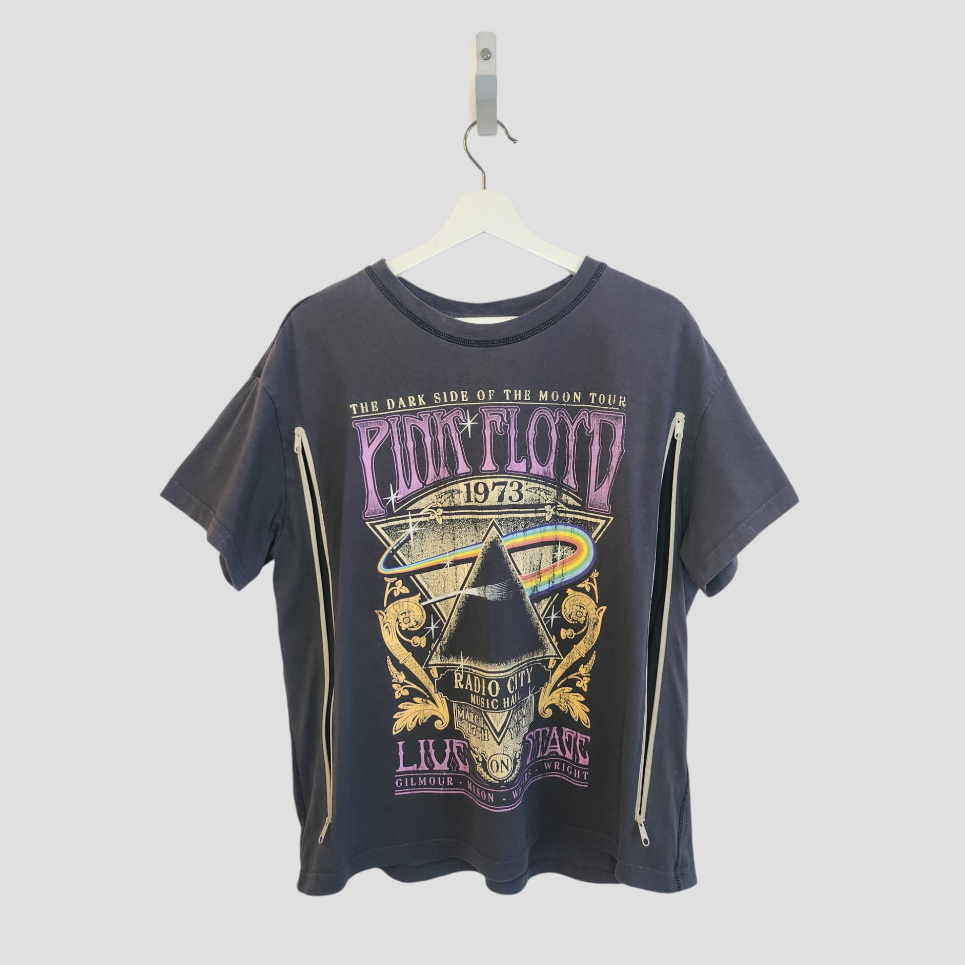An upcycled grey Pink Floyd Rainbow Band t-shirt by H&M (M, 100256) hangs on a white hanger. This preloved nursing top features long side zippers for easy breastfeeding and stylish comfort.