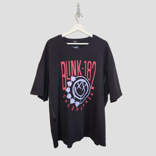 The boohoo Upcycled Breastfeeding & Pumping Black Blink-182 T-shirt UK16 (100294) features a bold pink and white band logo with gear graphic—an edgy choice for nursing or pumping fans. Shirt displayed on a white hanger against a light gray background.