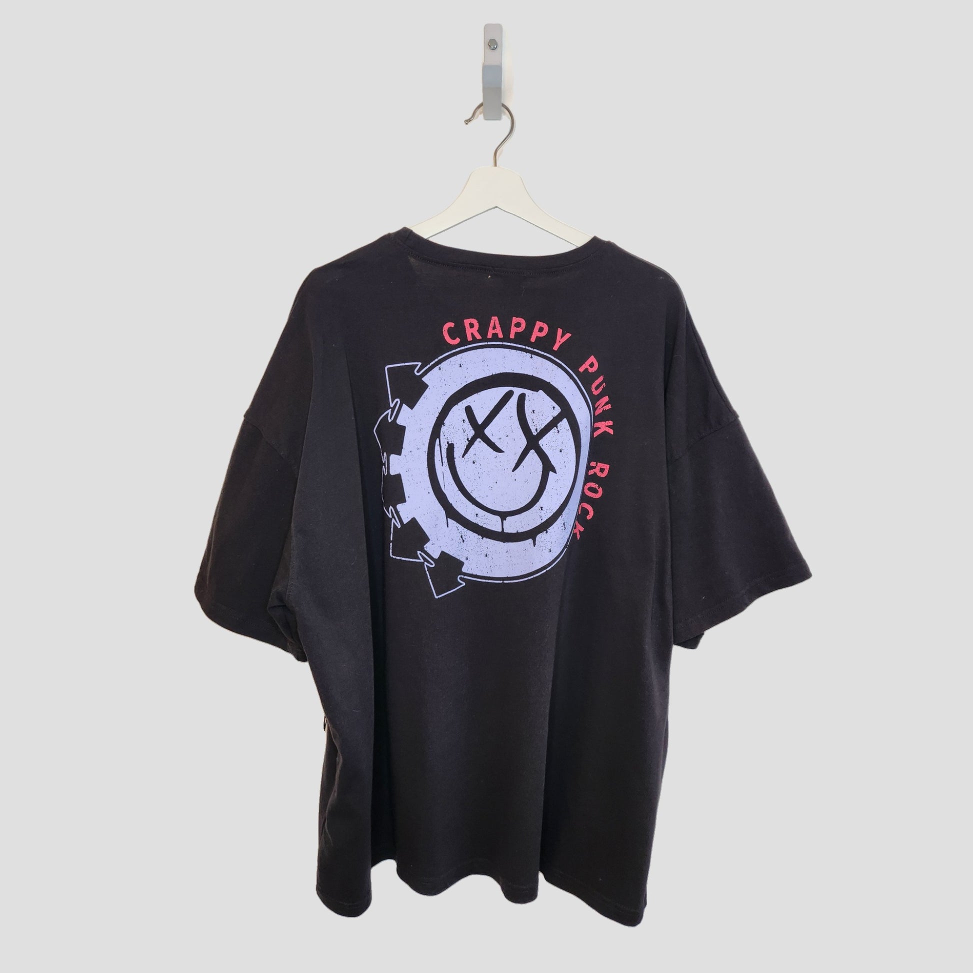 A black upcycled boohoo Blink 182 breastfeeding & pumping T-shirt (UK16, 100294) on a white hanger features a bold back graphic with a distressed smiley face, gears, and CRAPPY PUNK ROCK in red around the design.