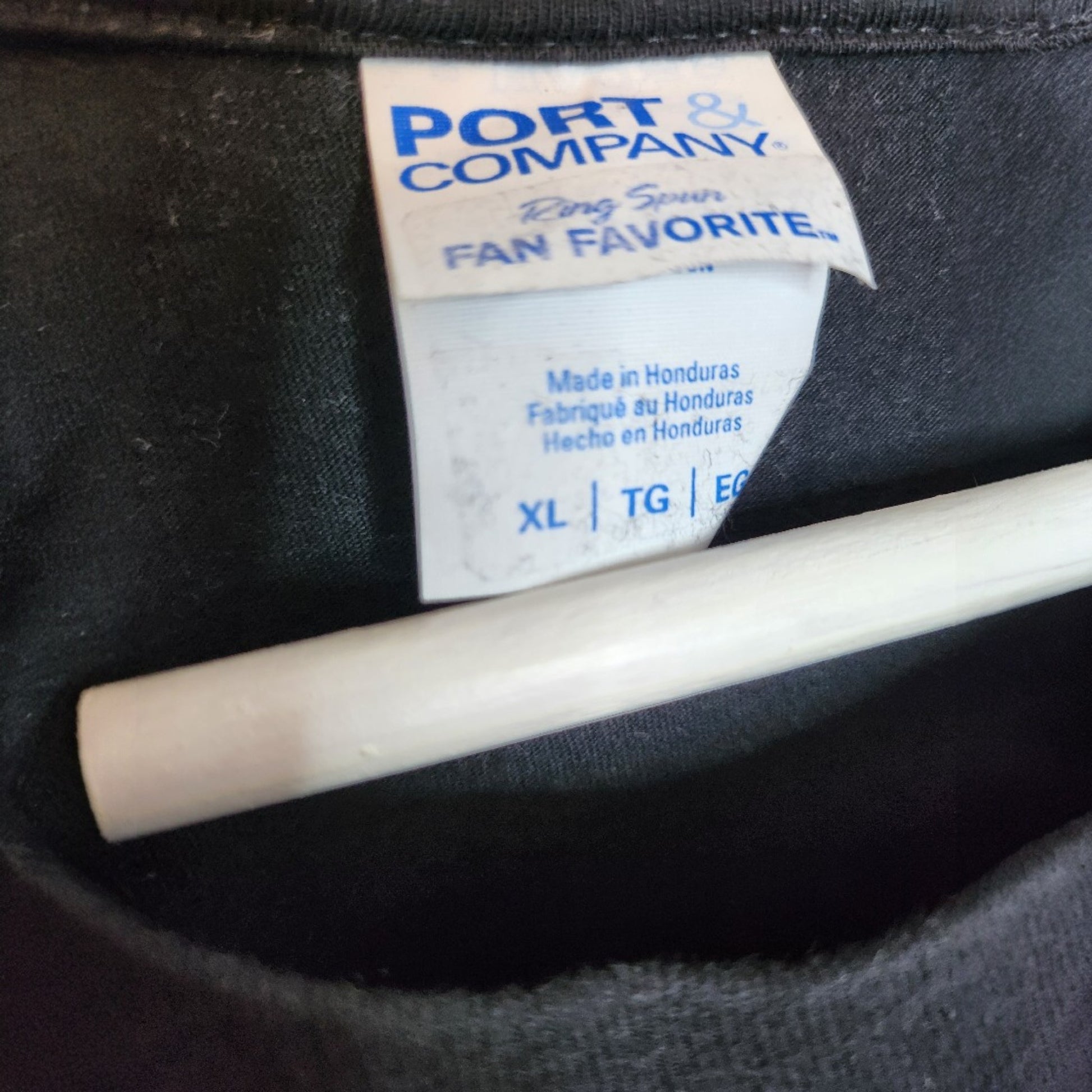 Close-up of a Port & Company clothing tag on an upcycled black Shake It Off t-shirt, size XL. Ideal preloved breastfeeding or pumping top for comfort and style. Product: Upcycled Breastfeeding & Pumping Black Shake It Off t-shirt (100298).