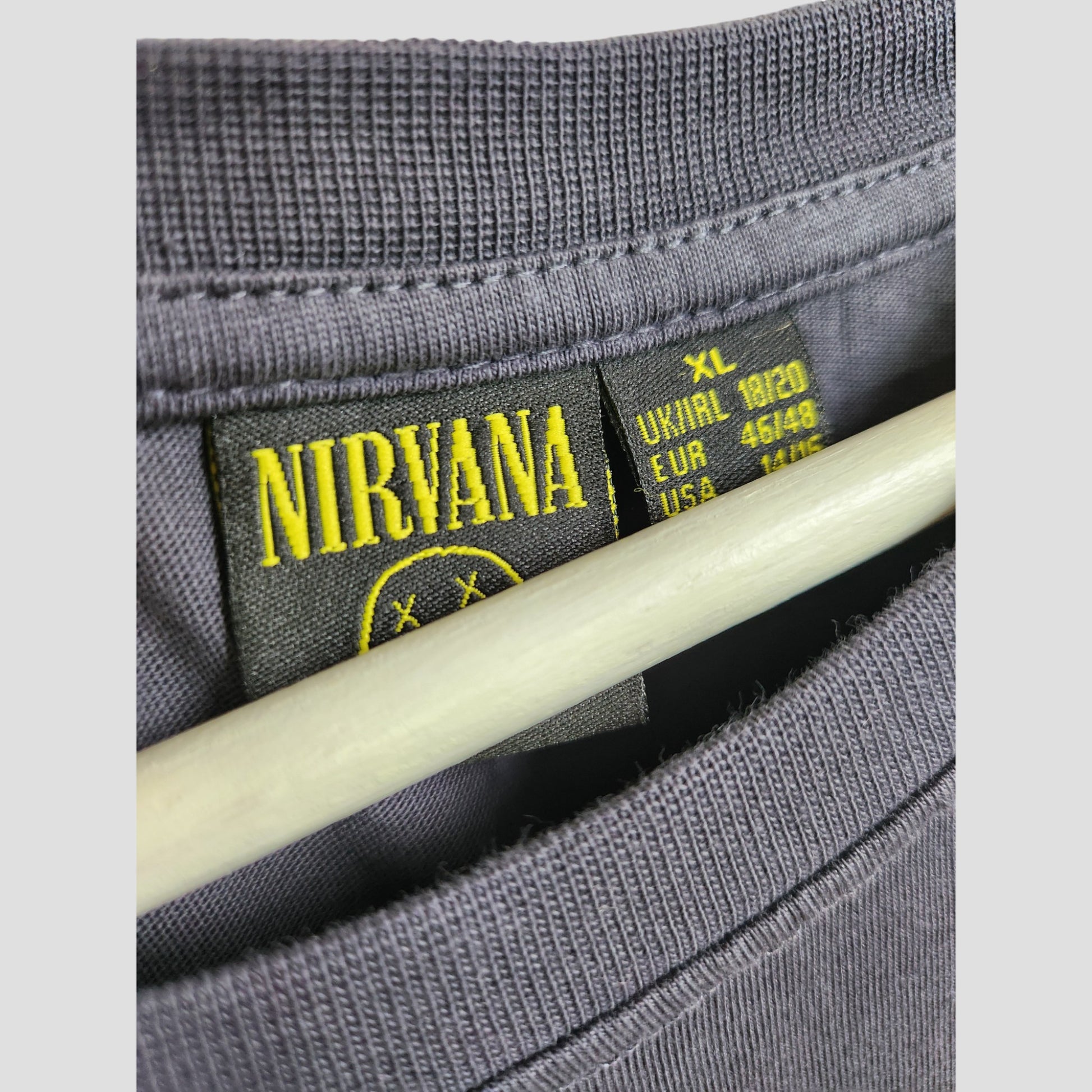 Close-up of a Primark Upcycled Breastfeeding & Pumping Grey Nirvana Yellow Smile Band t-shirt, size XL (UK18/20), on a hanger—an ideal affordable eco fashion find.