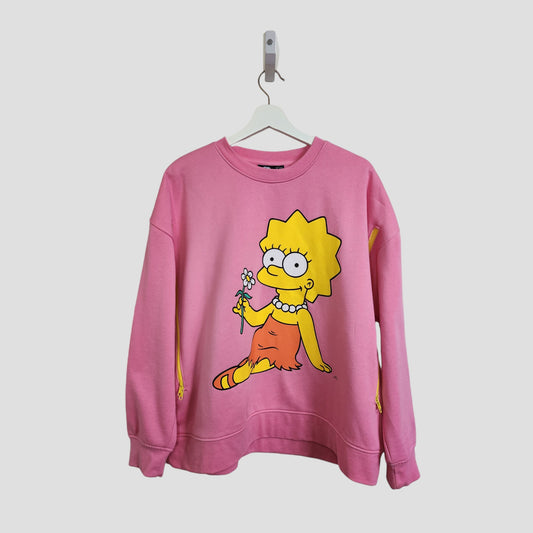The Primark Upcycled Breastfeeding & Pumping Pink Lisa Simpson Sweatshirt (L, UK14/16) features a large graphic of Lisa Simpson sitting cross-legged with a flower, displayed on a white hanger against a plain white background.