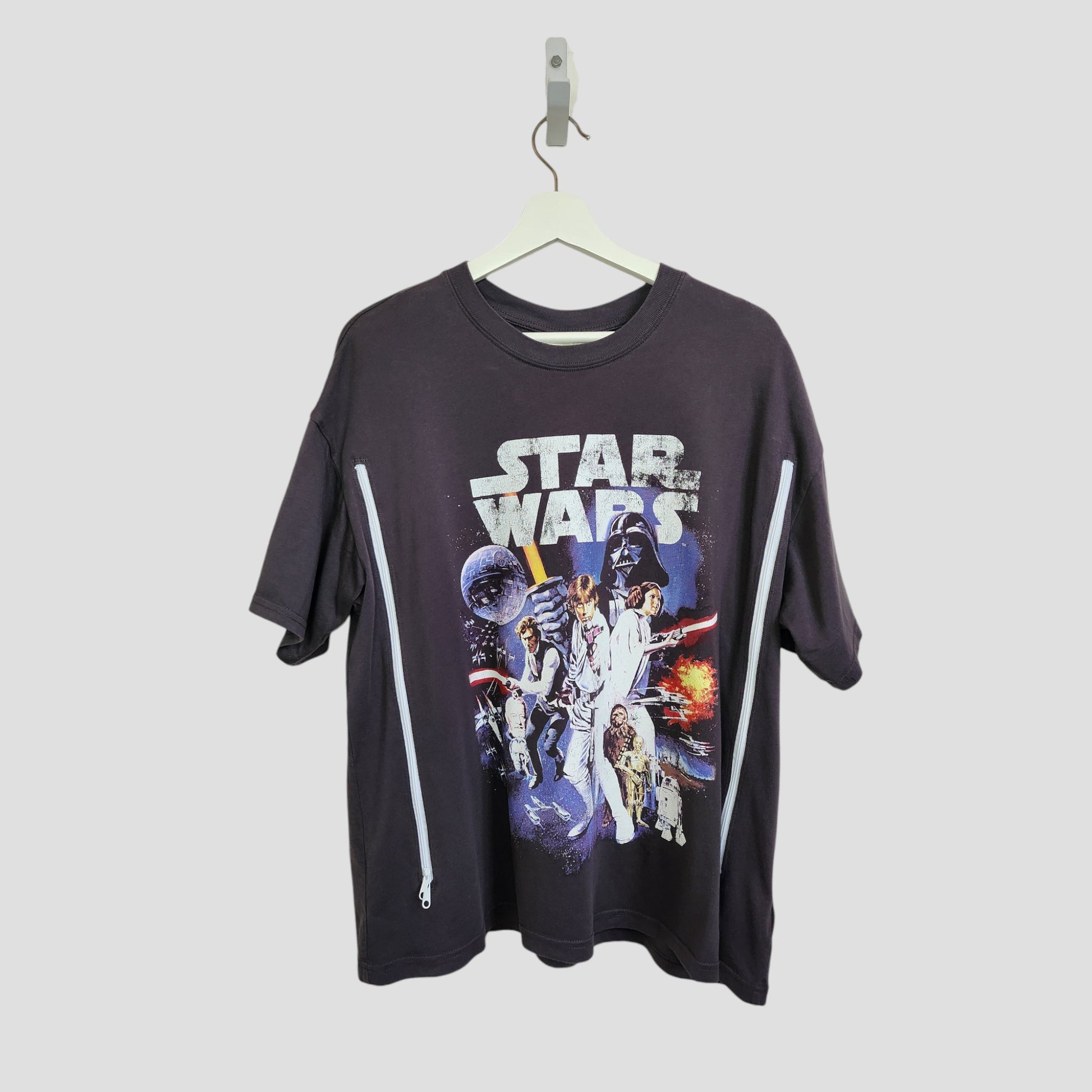 A grey H&M Upcycled Breastfeeding & Pumping Star Wars T-shirt (M) features a colorful front graphic, two diagonal side zippers, and is crafted from preloved clothing for eco-friendly, affordable style.