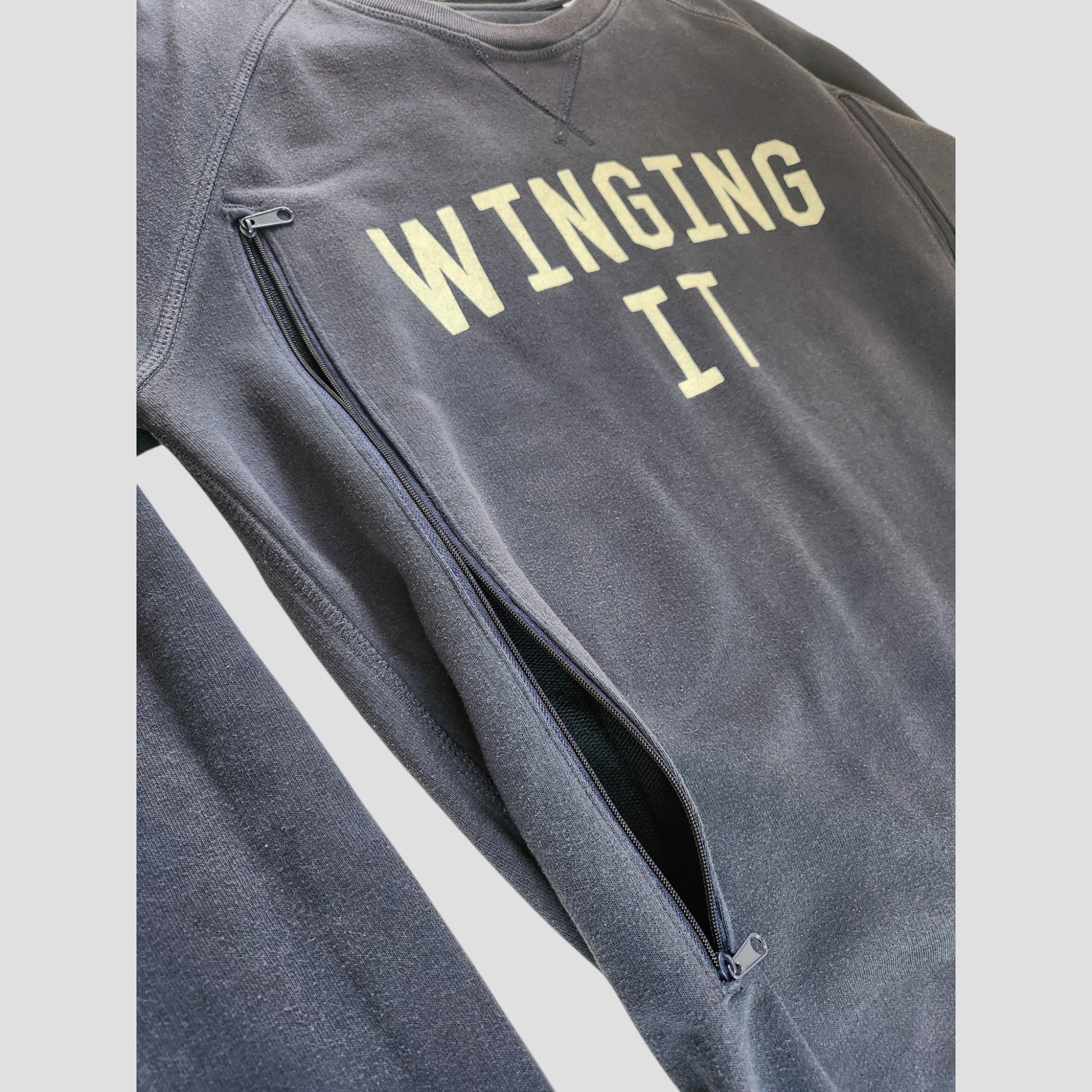 The Selfish Mother Upcycled Breastfeeding & Pumping Navy Blue Winging It Sweatshirt (L) features bold yellow lettering and a side zipper, offering affordable comfort and style for nursing or upcycled breastfeeding wear.