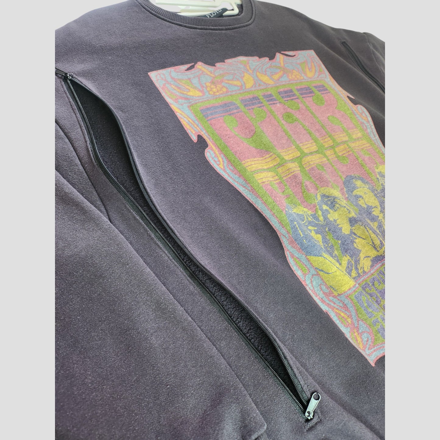 A close-up of a Primark Upcycled Breastfeeding & Pumping Grey Pink Floyd Band Sweatshirt (S, UK10/12, 100157), featuring a colorful vintage graphic and partially unzipped side zipper—perfect for eco-friendly, preloved fashion lovers.