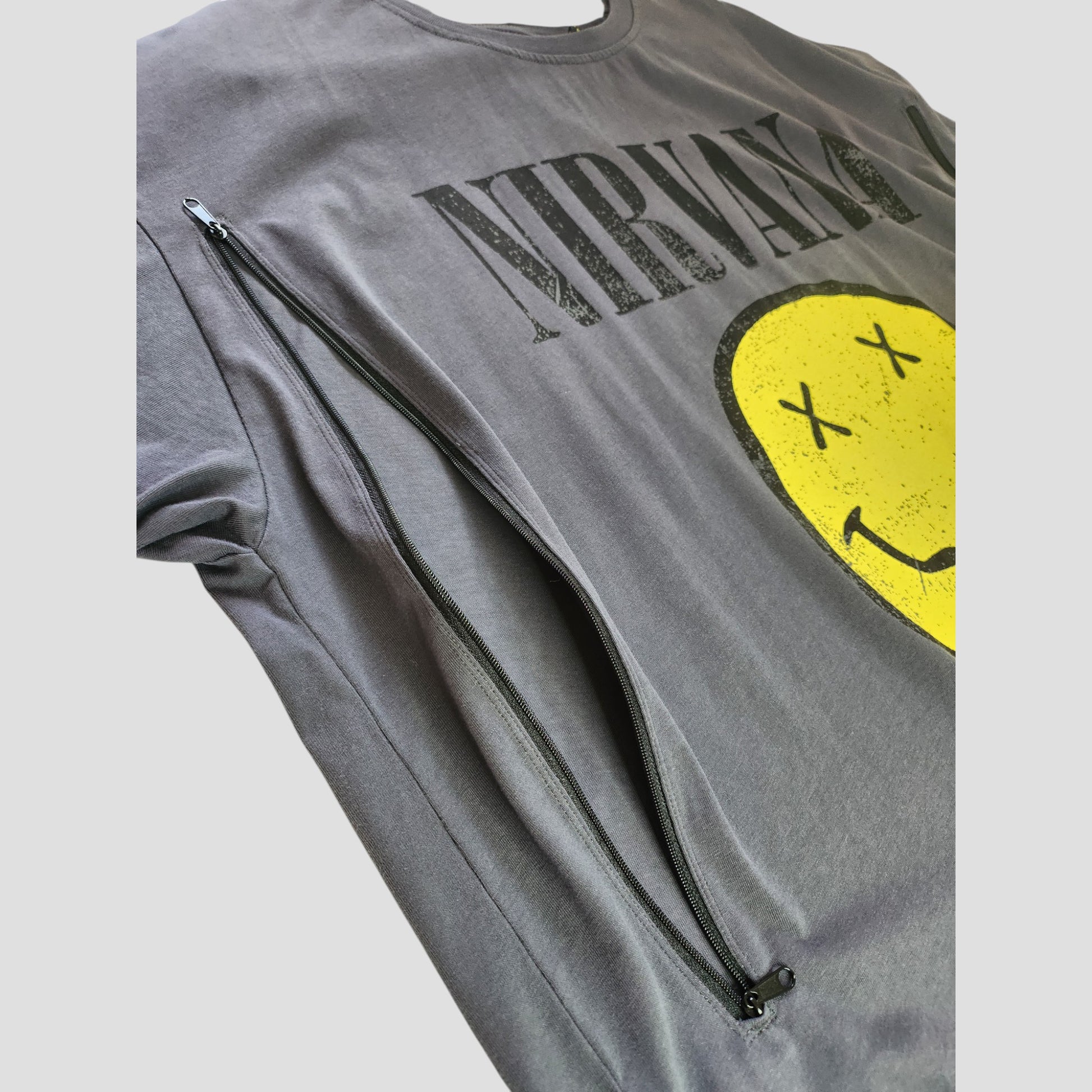 Primark's Upcycled Breastfeeding & Pumping Grey Nirvana Yellow Smile Band t-shirt (XL UK18/20) features a smiley face with X eyes, a large diagonal zipper, and is crafted from preloved clothing for eco-friendly, affordable style.