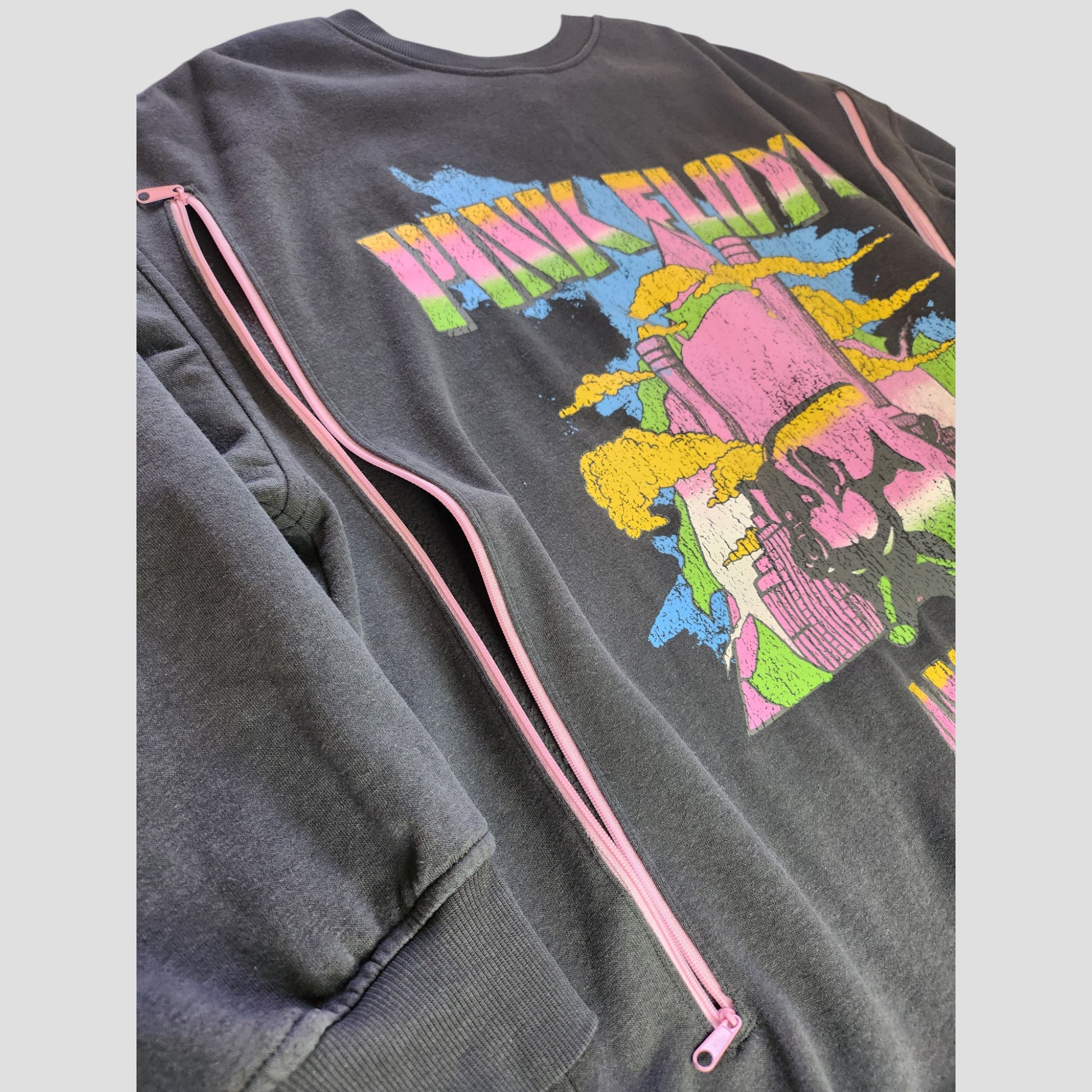 The H&M Upcycled Breastfeeding & Pumping Pink Floyd Band Sweatshirt (L) features a colorful abstract graphic and visible pink zipper on the sleeve, crafted from repurposed nursing clothing for a unique, sustainable style.