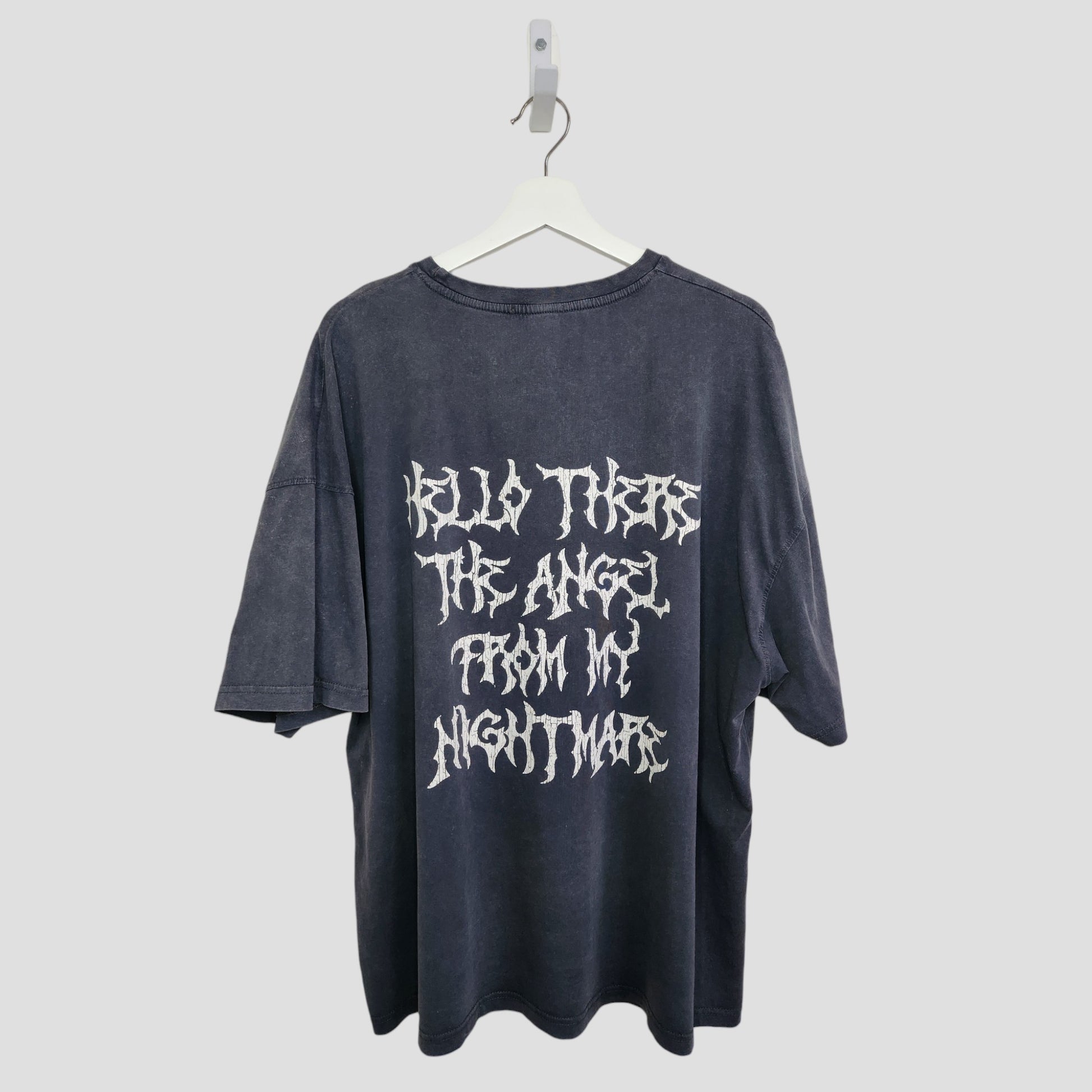 The Boohoo Upcycled Breastfeeding & Pumping Blink 182 Band T-shirt (M, 100324) features white stylized "HELLO THERE THE ANGEL FROM MY NIGHTMARE" text on the back, shown on a hanger against a plain light background.