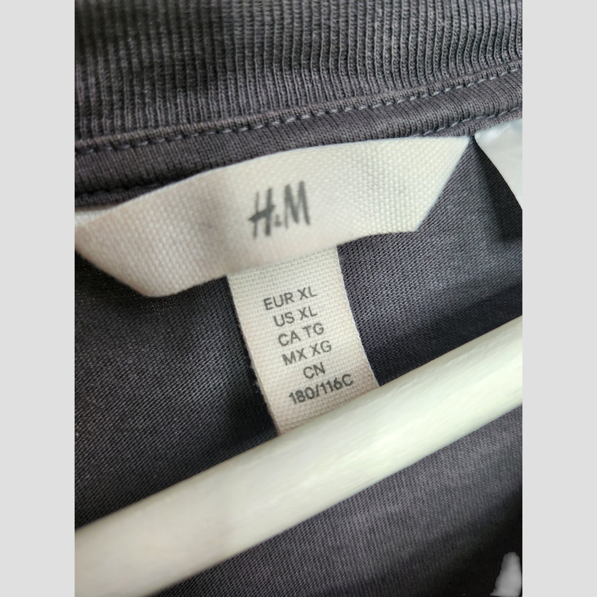 Close-up of an H&M label on an Upcycled Breastfeeding & Pumping Grey Rainbow Pink Floyd Band t-shirt, size EUR XL/US XL/CA TG/MX XG/CN 180/116C—ideal for eco-friendly maternity or preloved nursing wear.