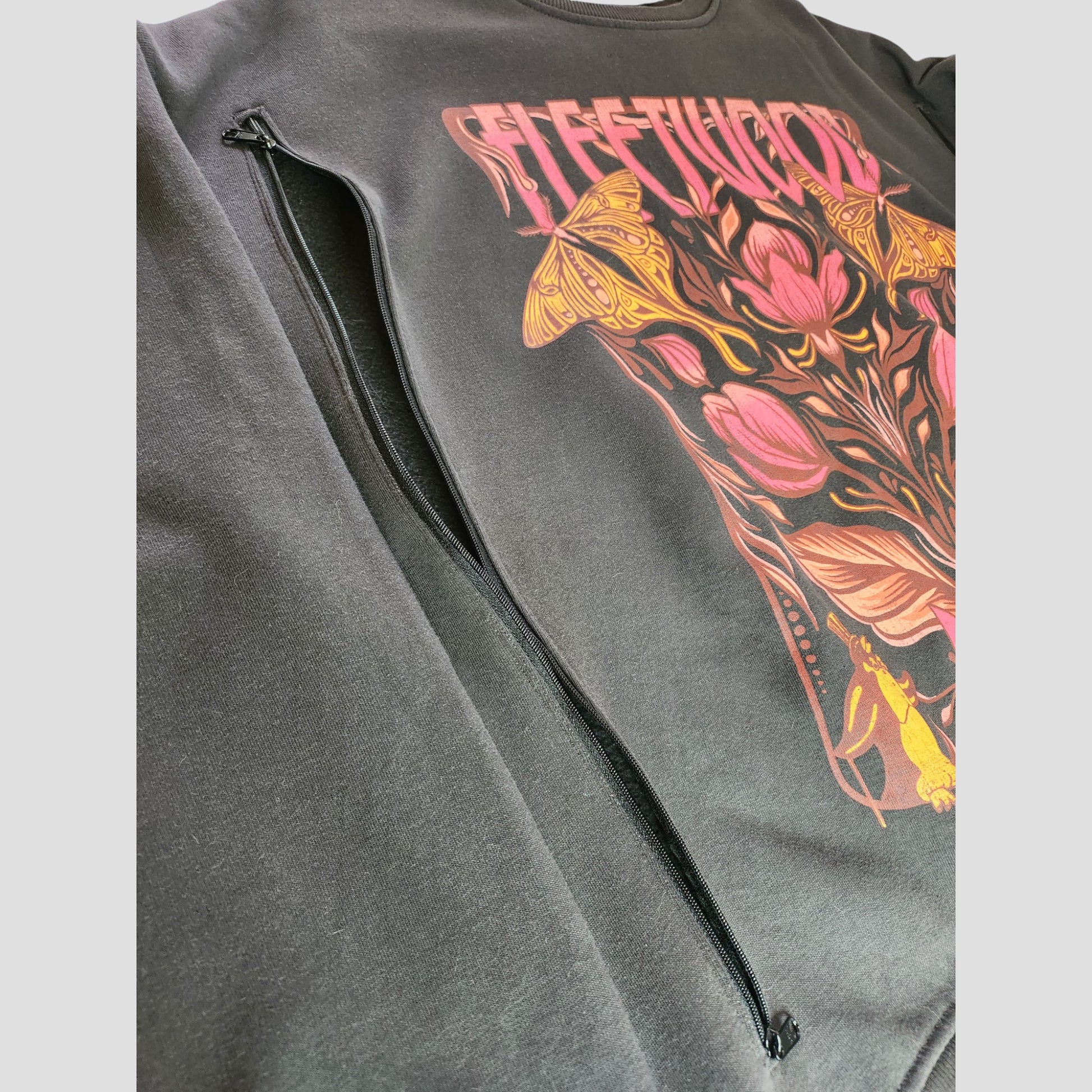 Primark Upcycled Breastfeeding & Pumping Floral Fleetwood Mac Band Sweatshirt (L, UK14/16) features a colorful floral and butterfly design, "FLEETWOOD" at the top, and a hidden side zipper pocket—made from repurposed nursing clothing.