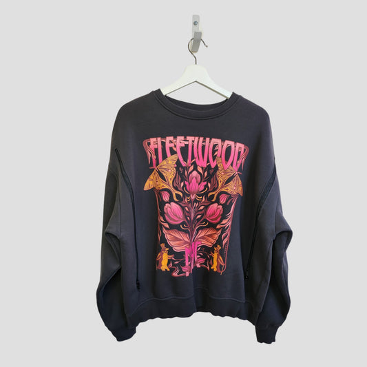 A dark grey oversized Fleetwood Mac floral band sweatshirt by Primark (size M) hangs on a white hanger, crafted from upcycled breastfeeding clothing for eco-friendly style. Features psychedelic flowers, mushrooms, and the band name on the front.