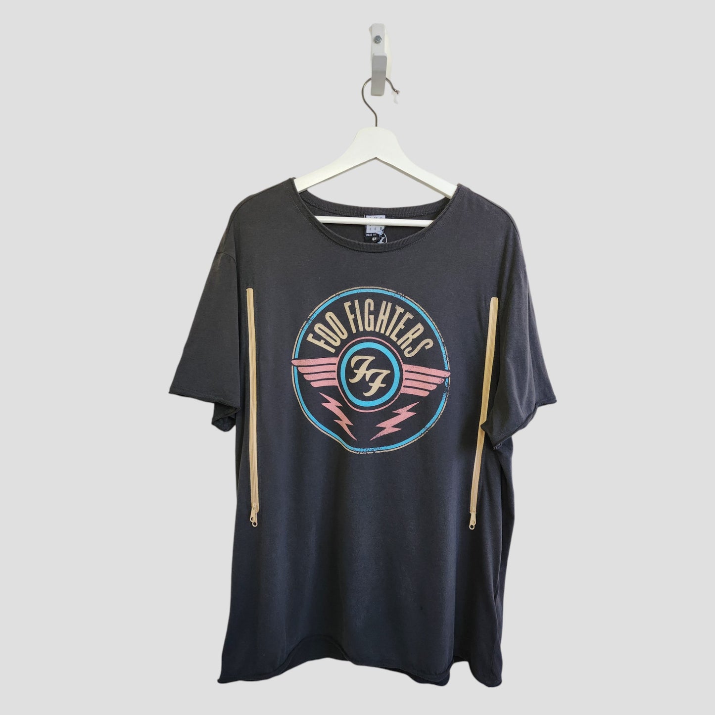 The Amplified Upcycled Breastfeeding & Pumping Grey Foo Fighters Band T-shirt 3XL (100329) is a stylish, eco-friendly pick for music-loving nursing moms. Displayed on a white hanger against a light gray background.