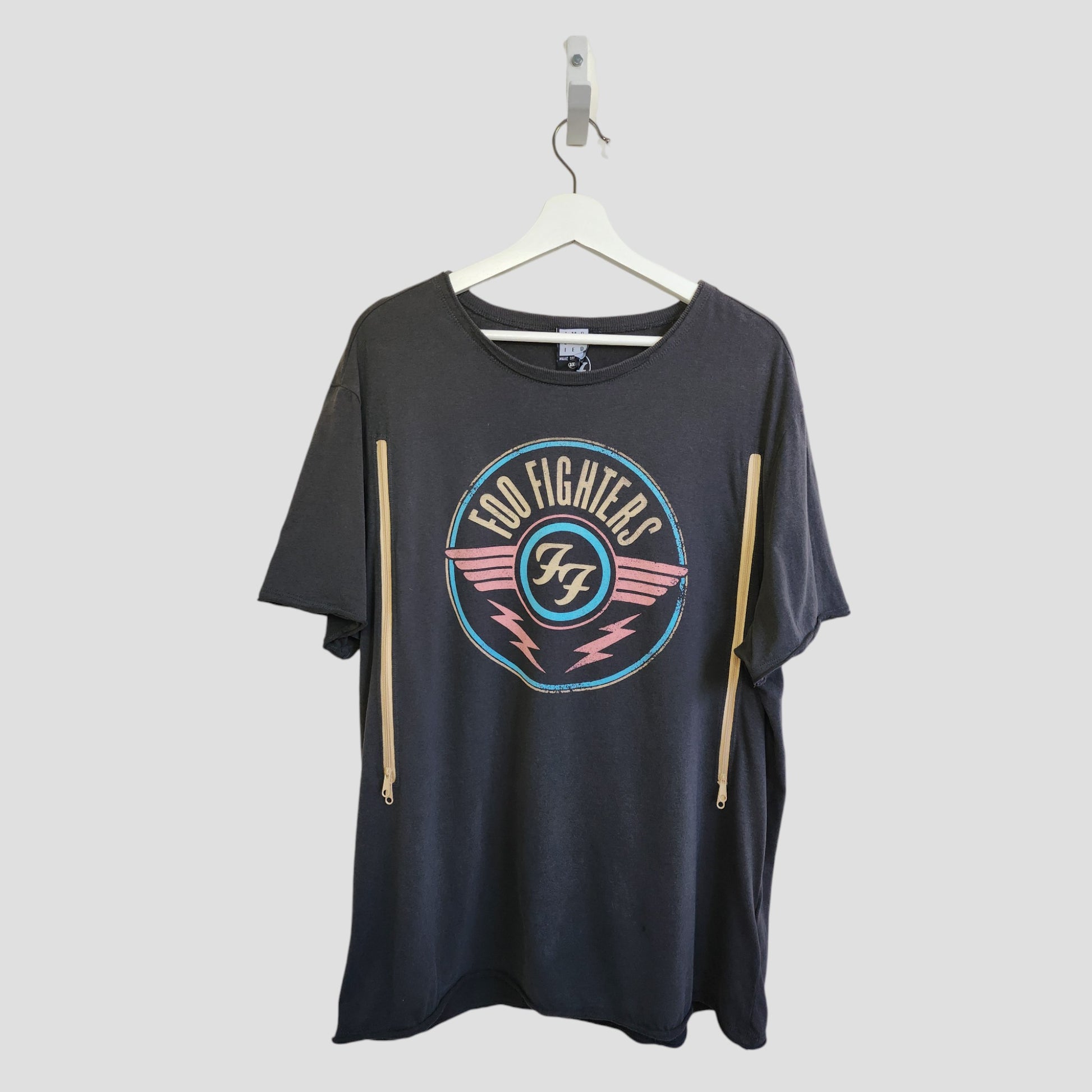 The Amplified Upcycled Breastfeeding & Pumping Grey Foo Fighters Band T-shirt 3XL (100329) is a stylish, eco-friendly pick for music-loving nursing moms. Displayed on a white hanger against a light gray background.
