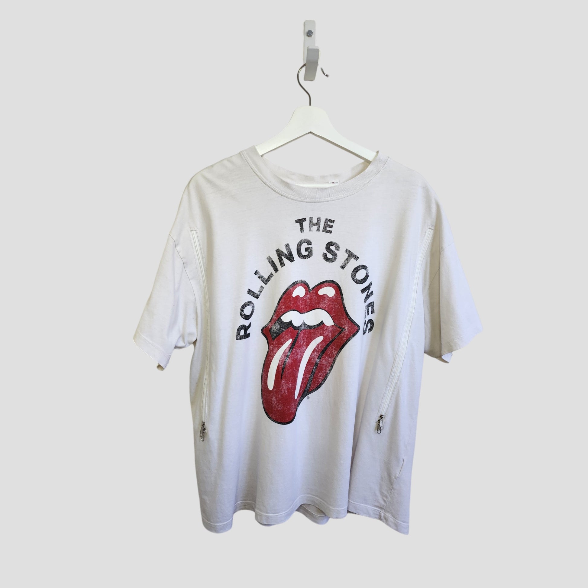 An upcycled H&M breastfeeding & pumping t-shirt in cream/red, featuring The Rolling Stones' bold logo and lips graphic—stylish, eco-friendly band tee for conscious nursing moms.