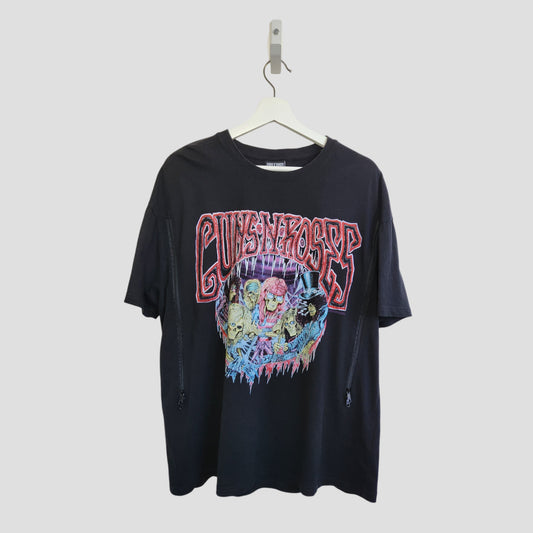 Primark Upcycled Breastfeeding & Pumping Black Guns N' Roses Band t-shirt (L, UK14/16) features colorful logos and skulls on the front. Crafted from upcycled nursing wear, it's an eco-friendly choice. Displayed on a hanger against a light gray background.