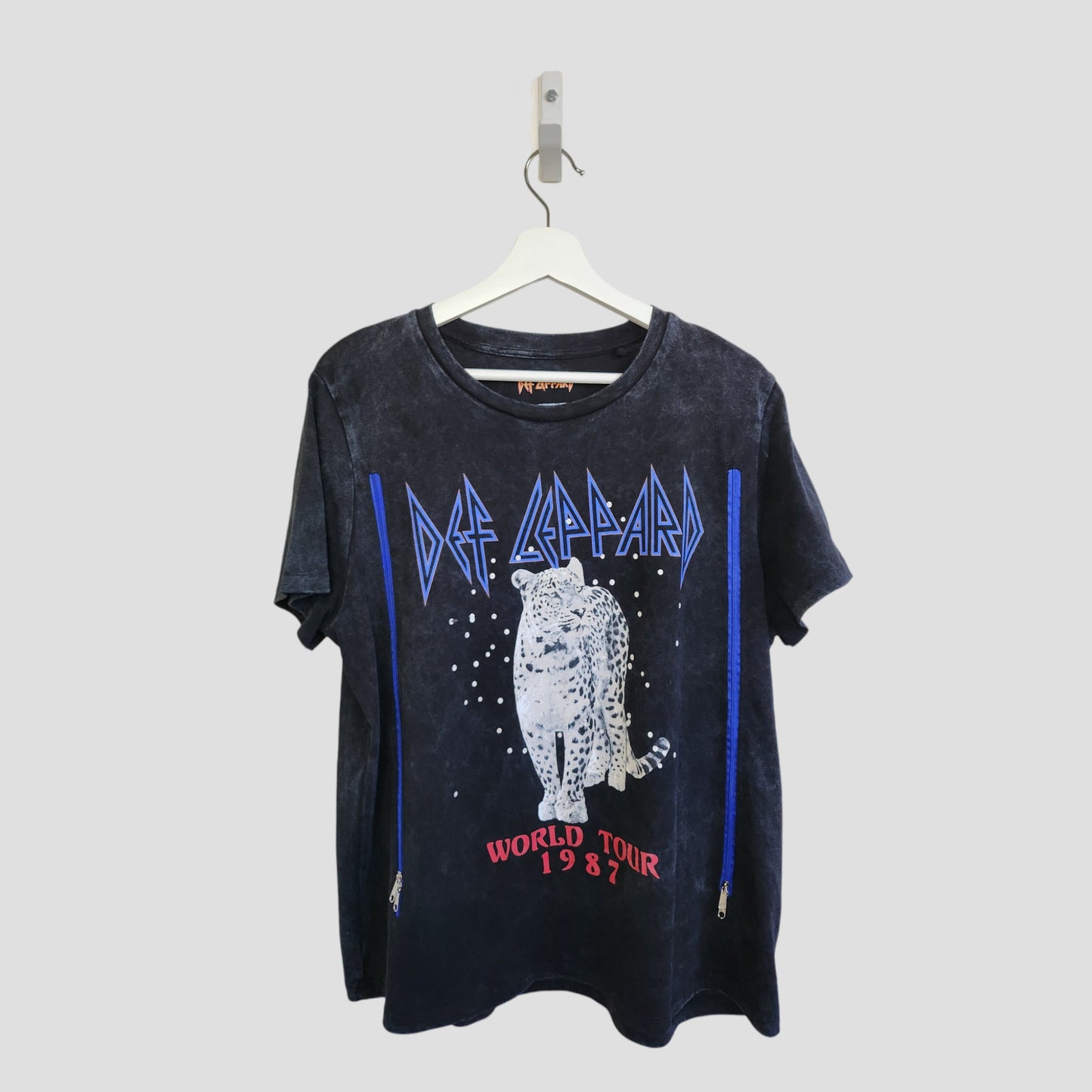 This upcycled Def Leppard Snow Band t-shirt (L) features a bold leopard graphic with blue accents and “Def Leppard” and “World Tour 1987” text. Stylish, sustainable, and designed for breastfeeding and pumping.