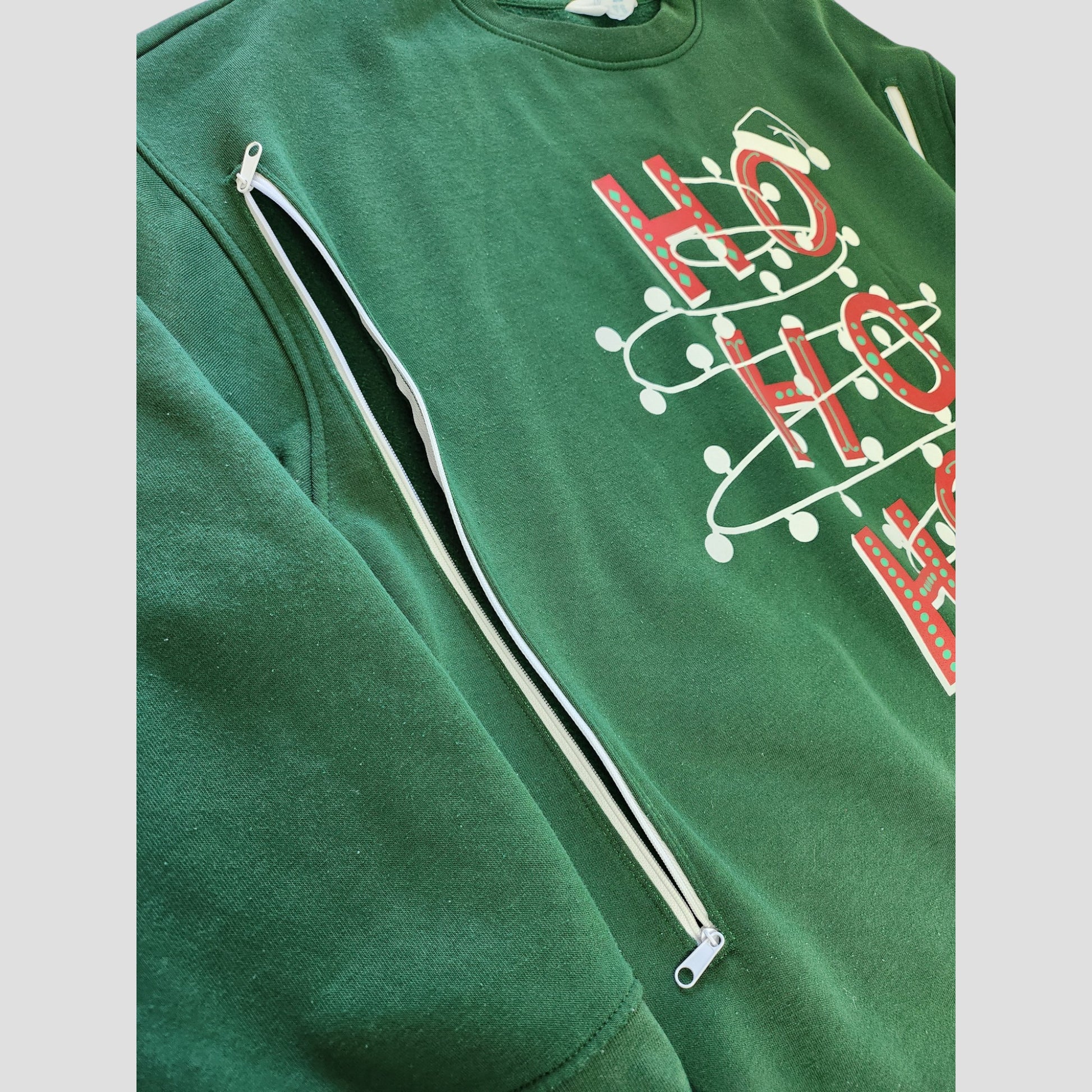 The Primark Upcycled Breastfeeding & Pumping Green HOHOHO Christmas Lights Sweatshirt 2XL features red and white HO HO HO letters outlined by string lights, a diagonal white zipper, and an eco-friendly design for festive style.
