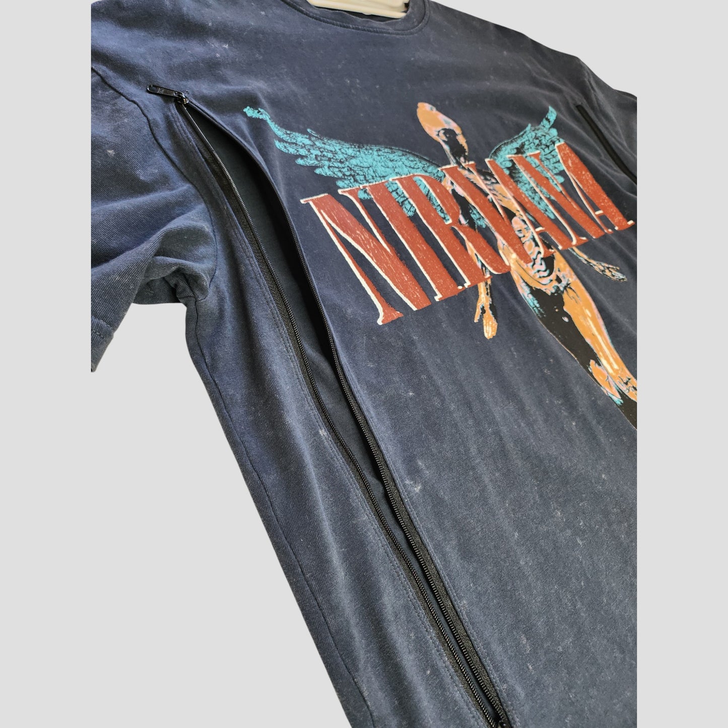 An upcycled Primark Nirvana Angel band t-shirt in grey (size M, UK12/14) features nursing and pumping access with a black side zipper; eco-friendly, oversized maternity wear.