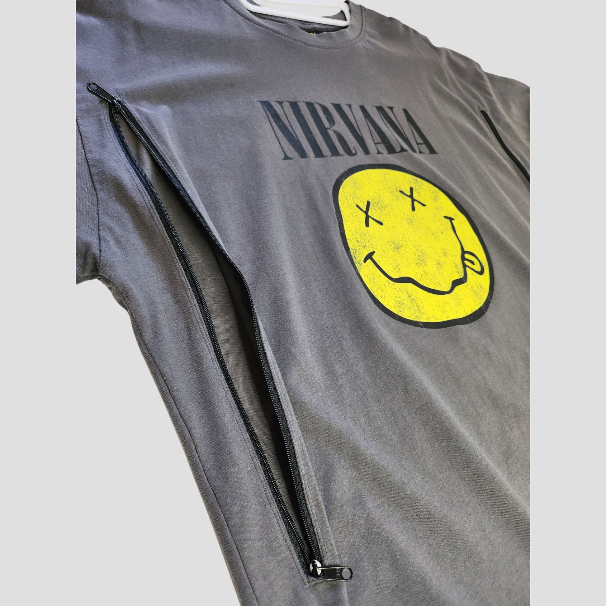 Primark Upcycled Breastfeeding & Pumping Nirvana Band T-shirt (UK12/14) features a grey base with yellow smile print, NIRVANA logo, and two long black zippers for easy nursing—stylish, eco-friendly maternity wear.