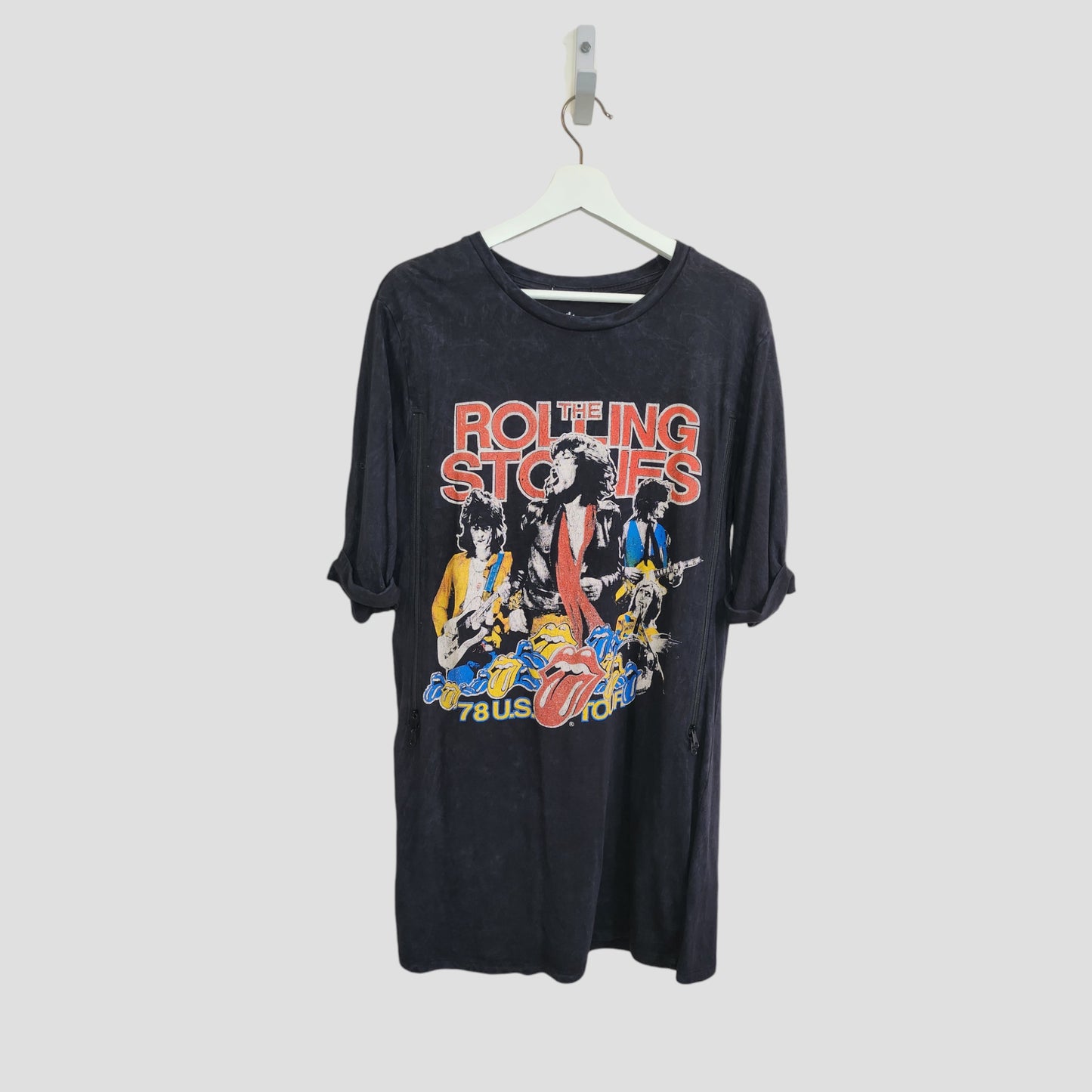 A black Boohoo Upcycled Breastfeeding & Pumping The Rolling Stones Band t-shirt dress (UK8) hangs on a white hanger, featuring bold graphics and "78 US Tour"—a stylish eco-friendly choice for fans who love preloved clothing.