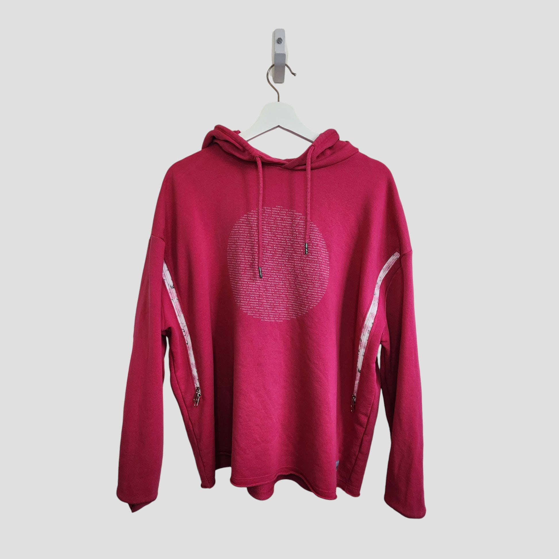 The Human Milk Upcycled Breastfeeding & Pumping Hoodie L (100216) in bright pink features a dotted circle chest design and visible zippered sleeve openings, shown on a white hanger against a plain light gray background.