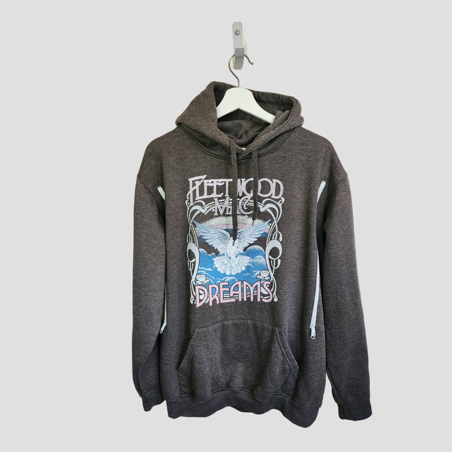 The Fleetwood Mac Upcycled Breastfeeding & Pumping Grey Dreams Band Hoodie UK12/14 features a white bird, clouds, and "Fleetwood Mac Dreams" graphic; eco-friendly and shown on a white hanger against a light background.
