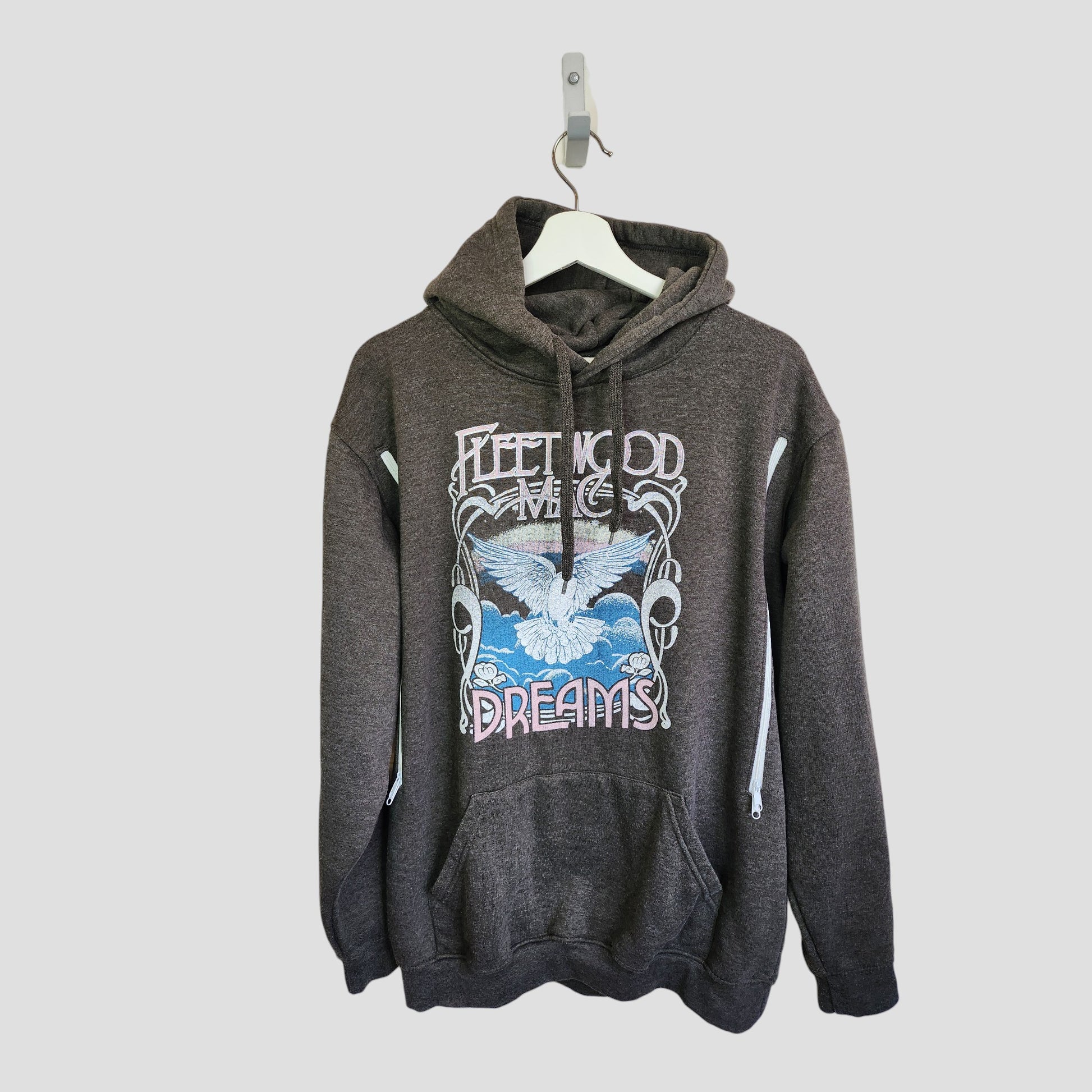 The Fleetwood Mac Upcycled Breastfeeding & Pumping Grey Dreams Band Hoodie UK12/14 features a white bird, clouds, and "Fleetwood Mac Dreams" graphic; eco-friendly and shown on a white hanger against a light background.