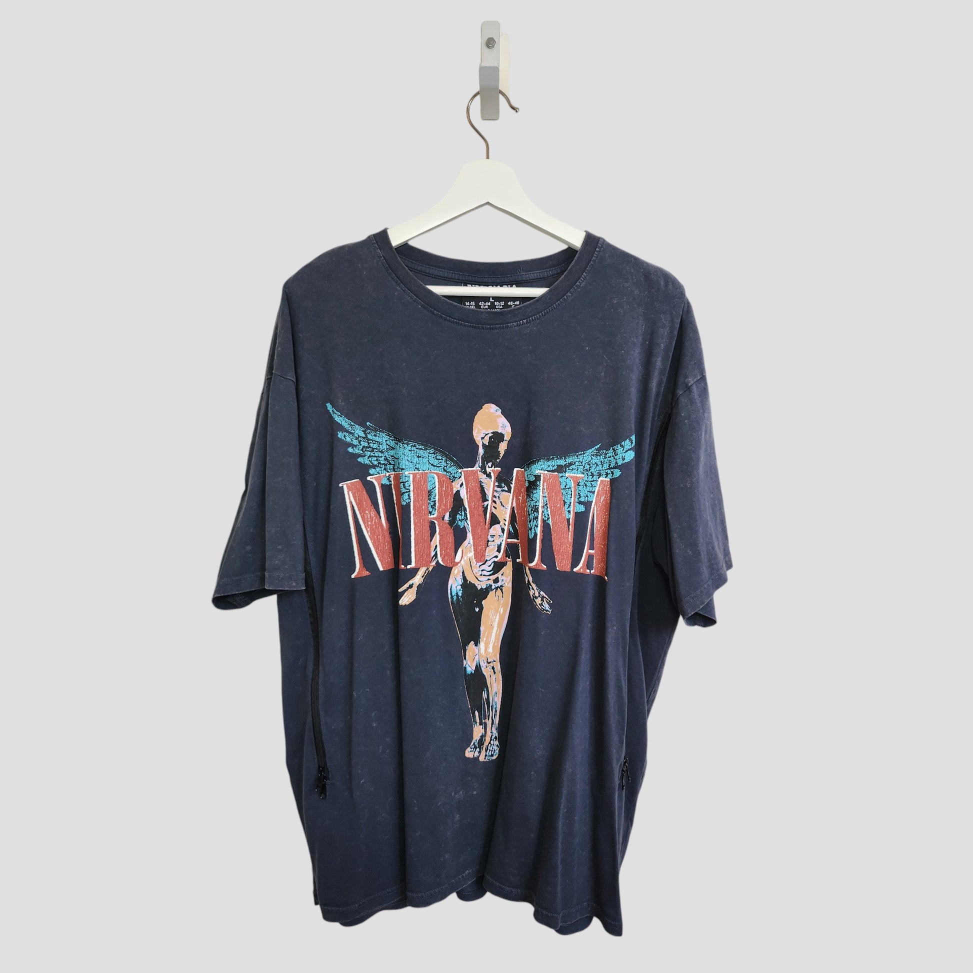 An upcycled Primark Nirvana band T-shirt (L, UK14/16) in grey/turquoise with a winged anatomical figure and bold red band name—eco-friendly nursing & pumping style with iconic appeal.