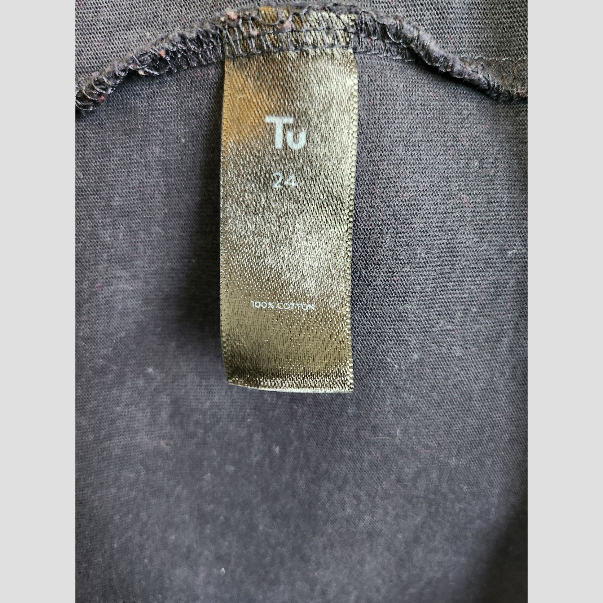 A black tag on a navy Tu UK24 t-shirt reads "Tu 24" and "100% cotton," making this upcycled Wonder Women nursing & pumping top an eco-friendly maternity wear choice.