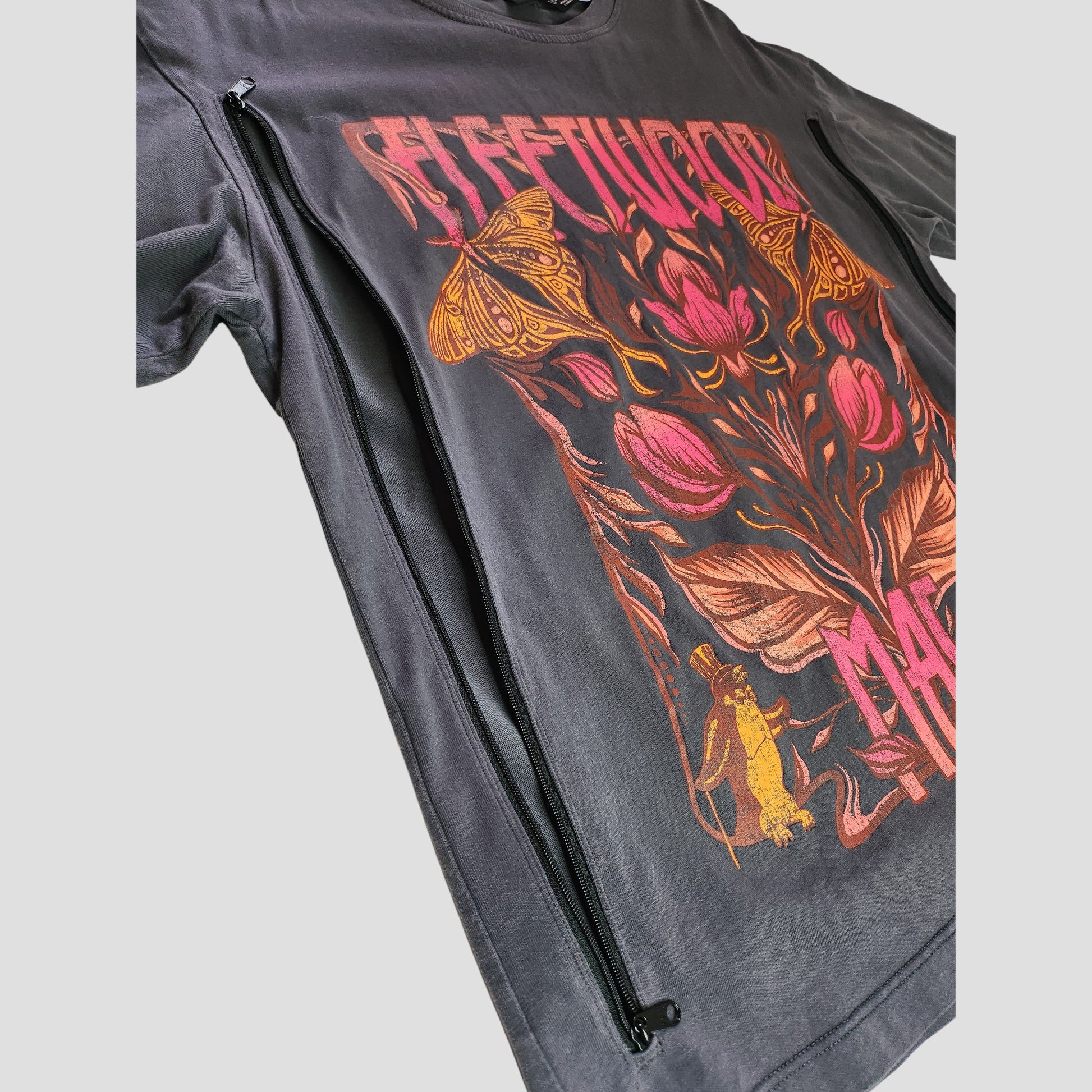 Primark’s upcycled oversized grey Fleetwood Mac floral band t-shirt (XS UK8/10) features side zippers for breastfeeding or pumping—an affordable eco-friendly option with stylish flowers, moths, and a yellow cat graphic.