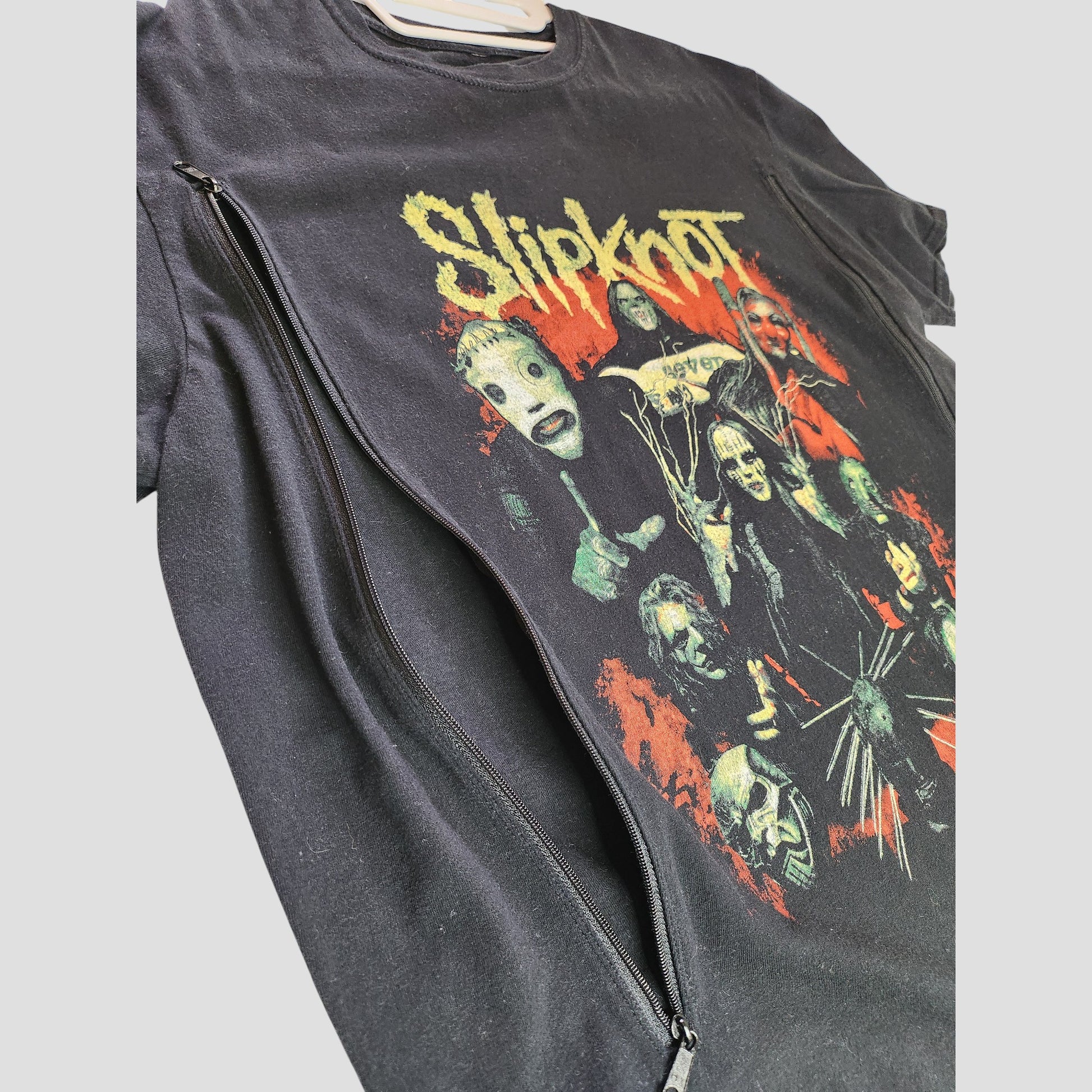 The Upcycled Breastfeeding (Nursing) & Pumping Black Slipknot Band t-shirt L by Slipknot features masked band member graphics, a yellow logo, and a large zipper—perfect edgy nursing wear for rock-loving moms.