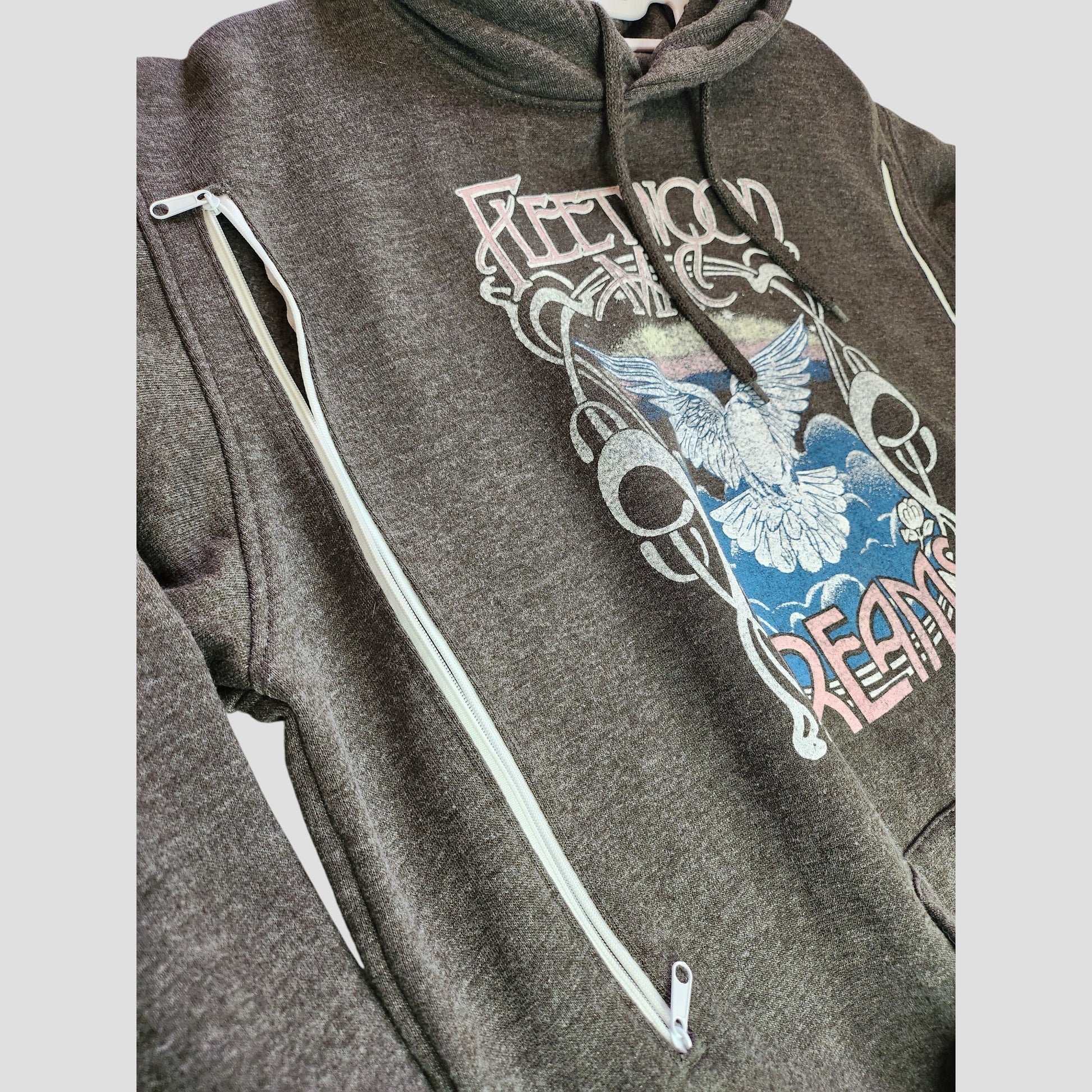 Upcycled Fleetwood Mac Dreams band hoodie (UK12/14) in dark grey with white sleeve and front zippers, featuring a colorful graphic of a white dove and blue sky—an eco-friendly choice for nursing, pumping, and music lovers.