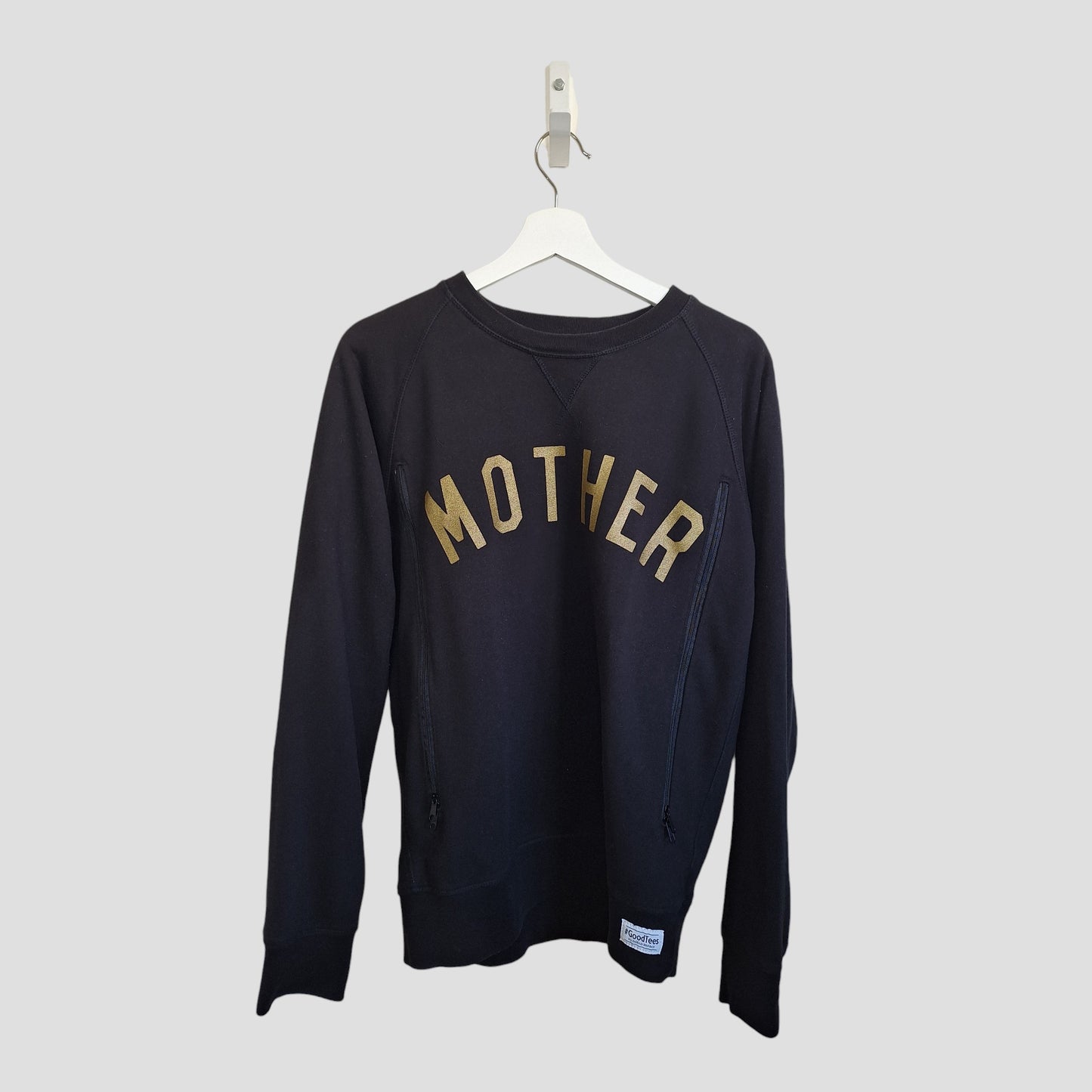 The Selfish Mother Upcycled Breastfeeding & Pumping Black/Gold MOTHER Sweatshirt (M, 100200) is an eco-friendly maternity top with "MOTHER" in bold yellow letters, shown on a white hanger against a light gray background.
