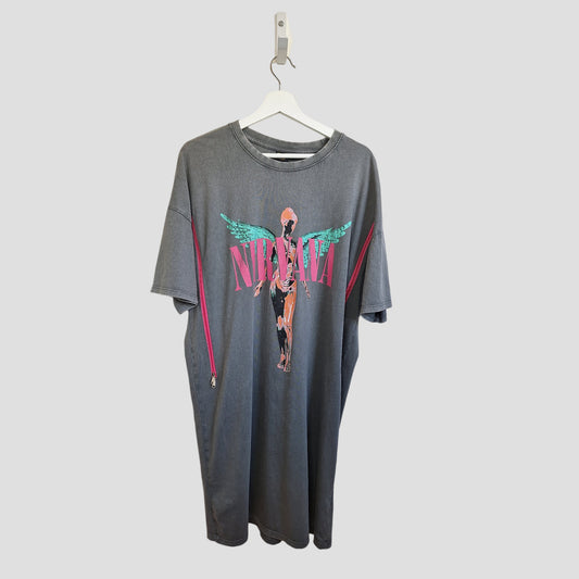 The Primark Upcycled Breastfeeding & Pumping Grey/Pink Angel Nirvana Band t-shirt dress (M, UK12/14) features pink band text and a teal-winged angel on the front, shown hanging on a white hanger against a plain background.