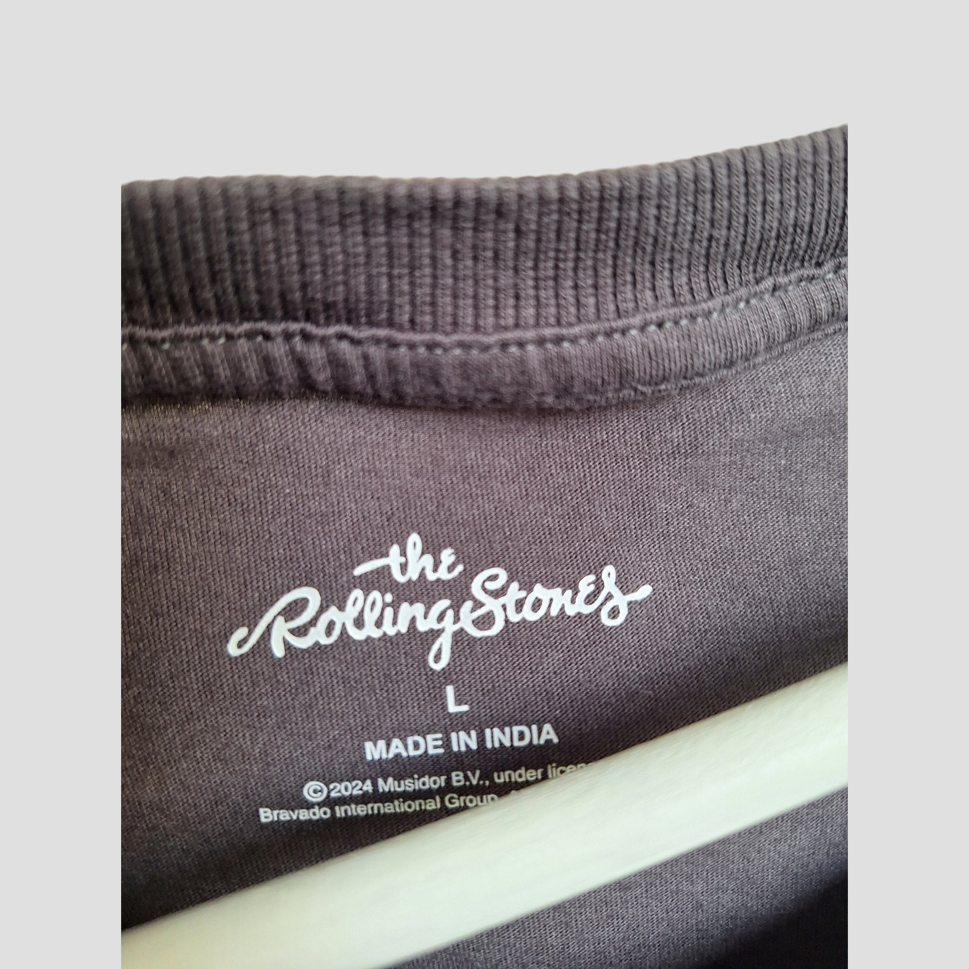 Close-up of a Primark label inside an upcycled grey The Rolling Stones band t-shirt, size L—an eco-friendly, preloved breastfeeding and pumping shirt (100335) made for fans seeking sustainable fashion.