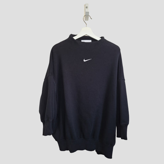 A preloved Nike Upcycled Breastfeeding & Pumping Black Funnel Neck Oversized Sweatshirt (M), featuring long sleeves and a white swoosh logo on the chest, shown on a white hanger against a light gray background.