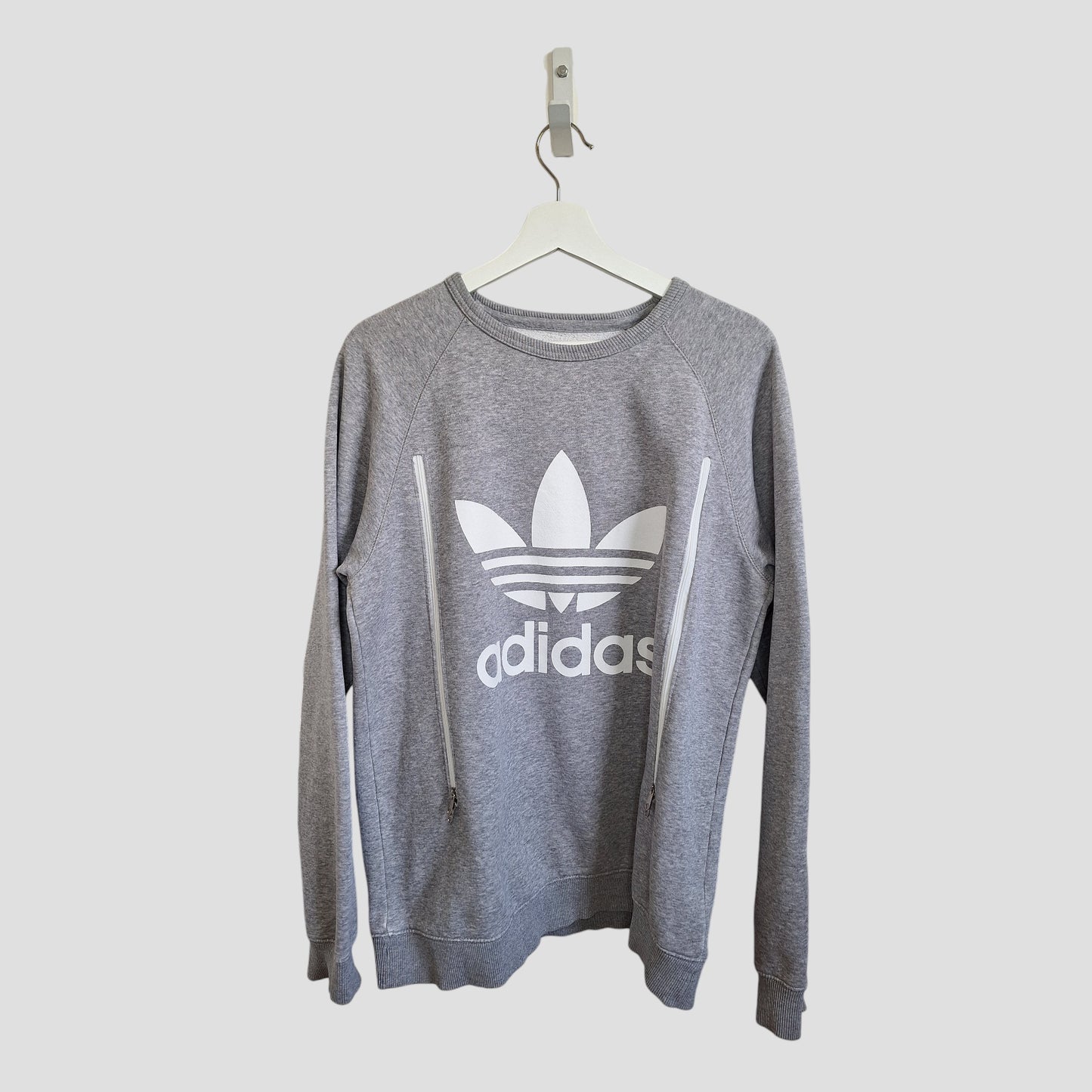 A preloved Adidas Upcycled Breastfeeding & Pumping Grey/White Logo Sweatshirt (UK14, L) hangs on a white hanger against a plain light background.