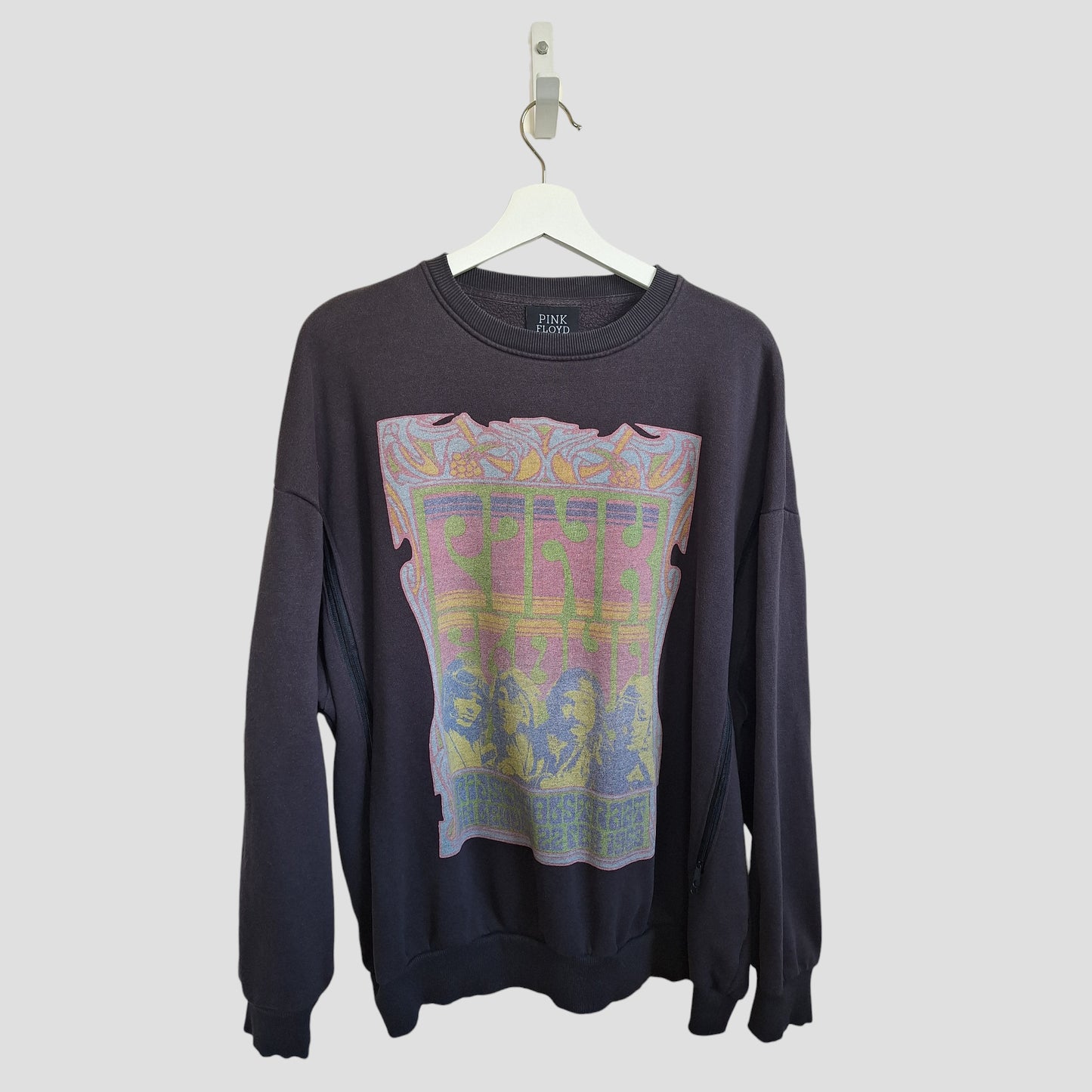 Primark's Upcycled Breastfeeding & Pumping Grey Pink Floyd Band Sweatshirt (M, UK12/14) is crafted from repurposed nursing wear for an eco-friendly touch, featuring a bold graphic and hanging on a white hanger against a light background.