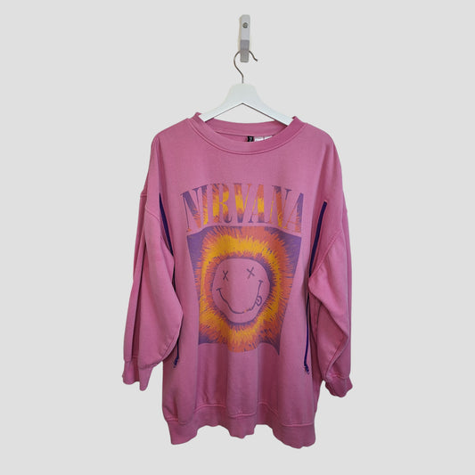 The H&M Upcycled Breastfeeding & Pumping Pink Nirvana Smile Band Sweatshirt (L, 100343) features a yellow sun and smiley face with X eyes, hanging on a white hanger against a plain light background.