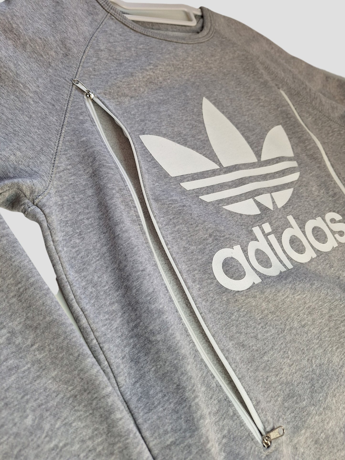 This preloved Adidas Upcycled Breastfeeding & Pumping Grey/White Logo Sweatshirt (L, UK14) features diagonal zippers for nursing—ideal for fans of unique, sustainable maternity wear.