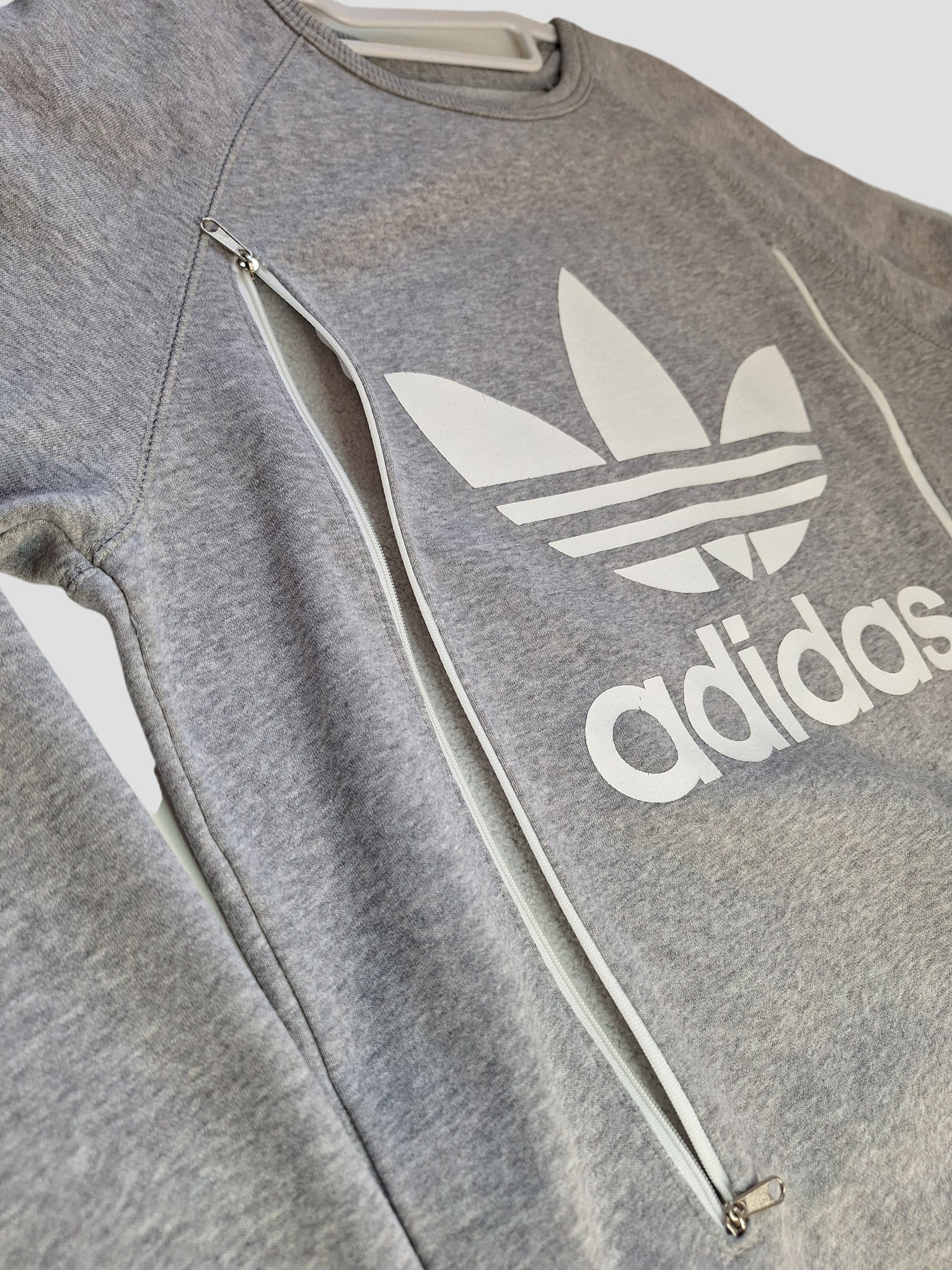 This preloved Adidas Upcycled Breastfeeding & Pumping Grey/White Logo Sweatshirt (L, UK14) features diagonal zippers for nursing—ideal for fans of unique, sustainable maternity wear.