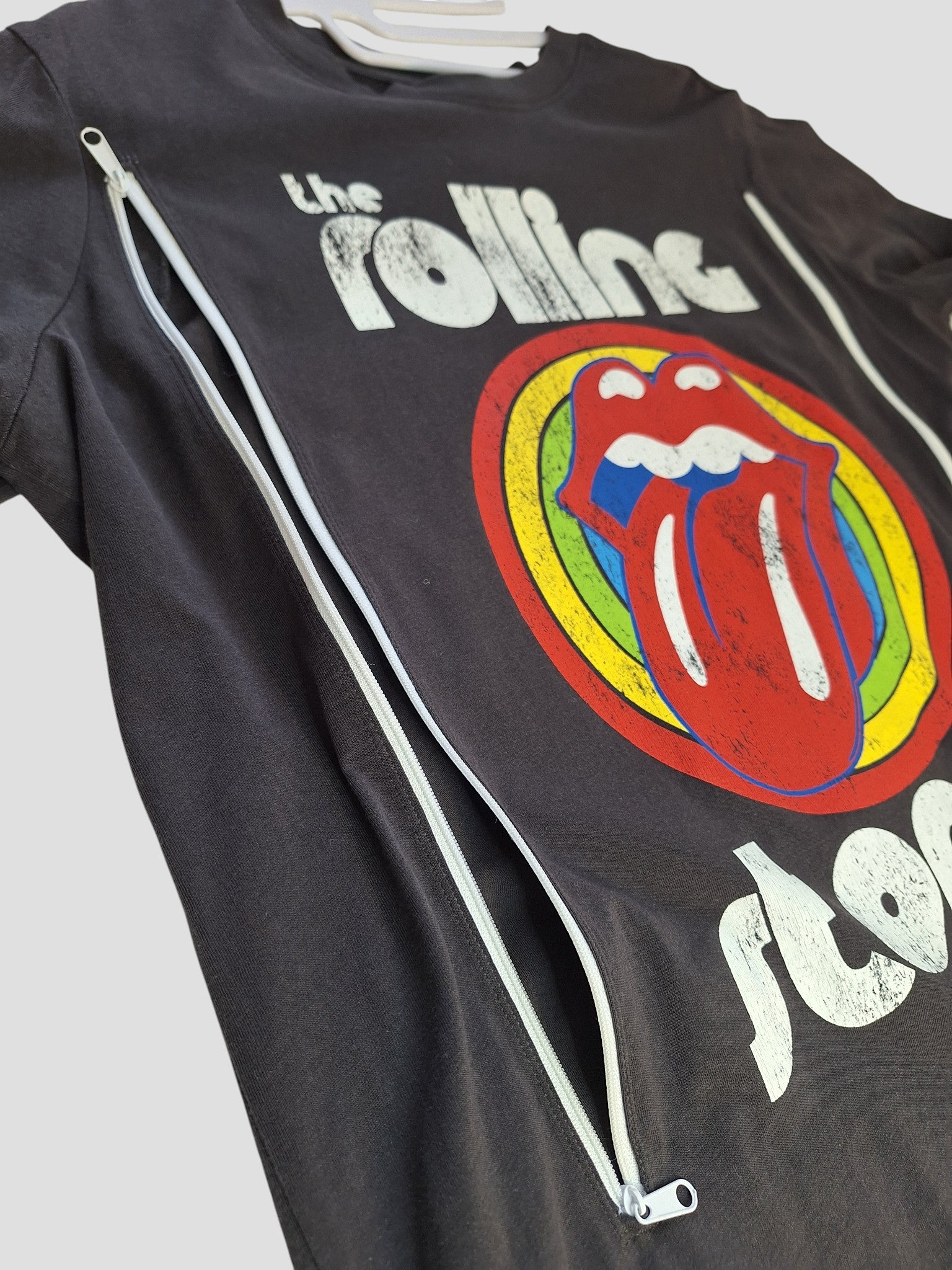 This upcycled H&M nursing & pumping t-shirt (M, 100193) features The Rolling Stones' rainbow tongue logo with band text and two white front zippers, blending vintage style and breastfeeding functionality.
