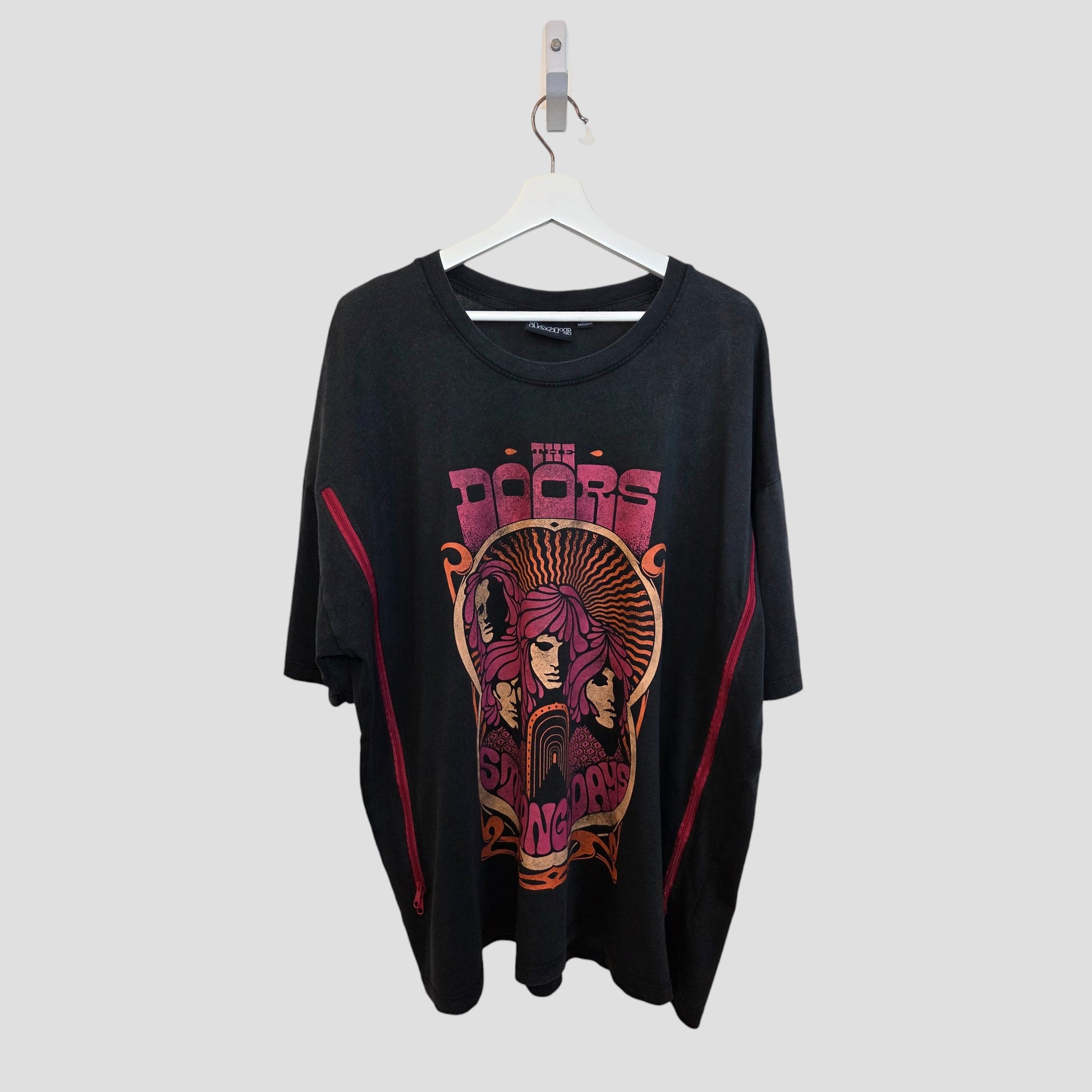 This upcycled Primark XL (UK18/20) black/burgundy The Doors nursing & pumping T-shirt (100362) features psychedelic red and yellow artwork. Shown oversized on a white hanger with a plain light gray background.